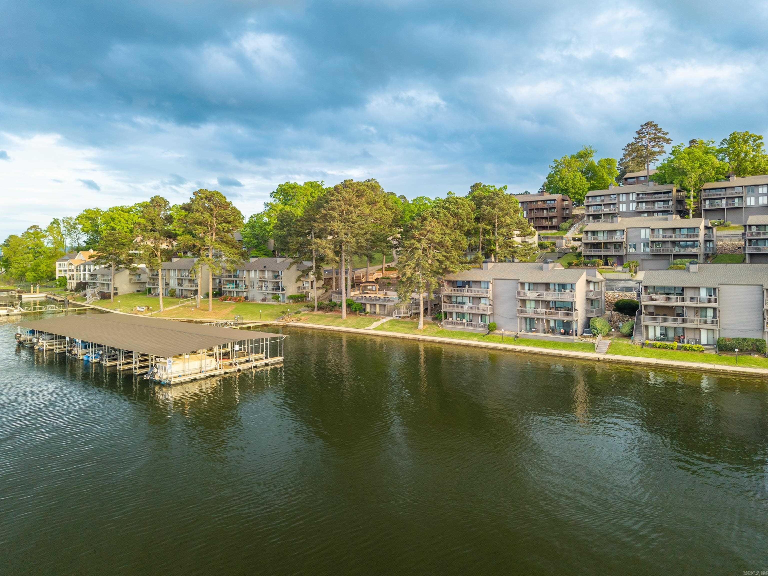 Updated lakefront condo right on the water available just in time for SUMMER! This gated community is convenient to restaurants, shopping, Oaklawn, and all Hot Springs has to offer! Immediately when you walk through the front door, this condo boasts tons of natural light and spectacular wide open water views! The deck spans the width of the unit-perfect for entertaining and taking in the perfect views. Boat slip with new boat lift. Most of Primary bedroom furniture stays with the unit. New HVAC 2023 and Water Heater 2025. This property checks all the boxes for a nightly rental/investment opportunity/vacation OR permanent residence!