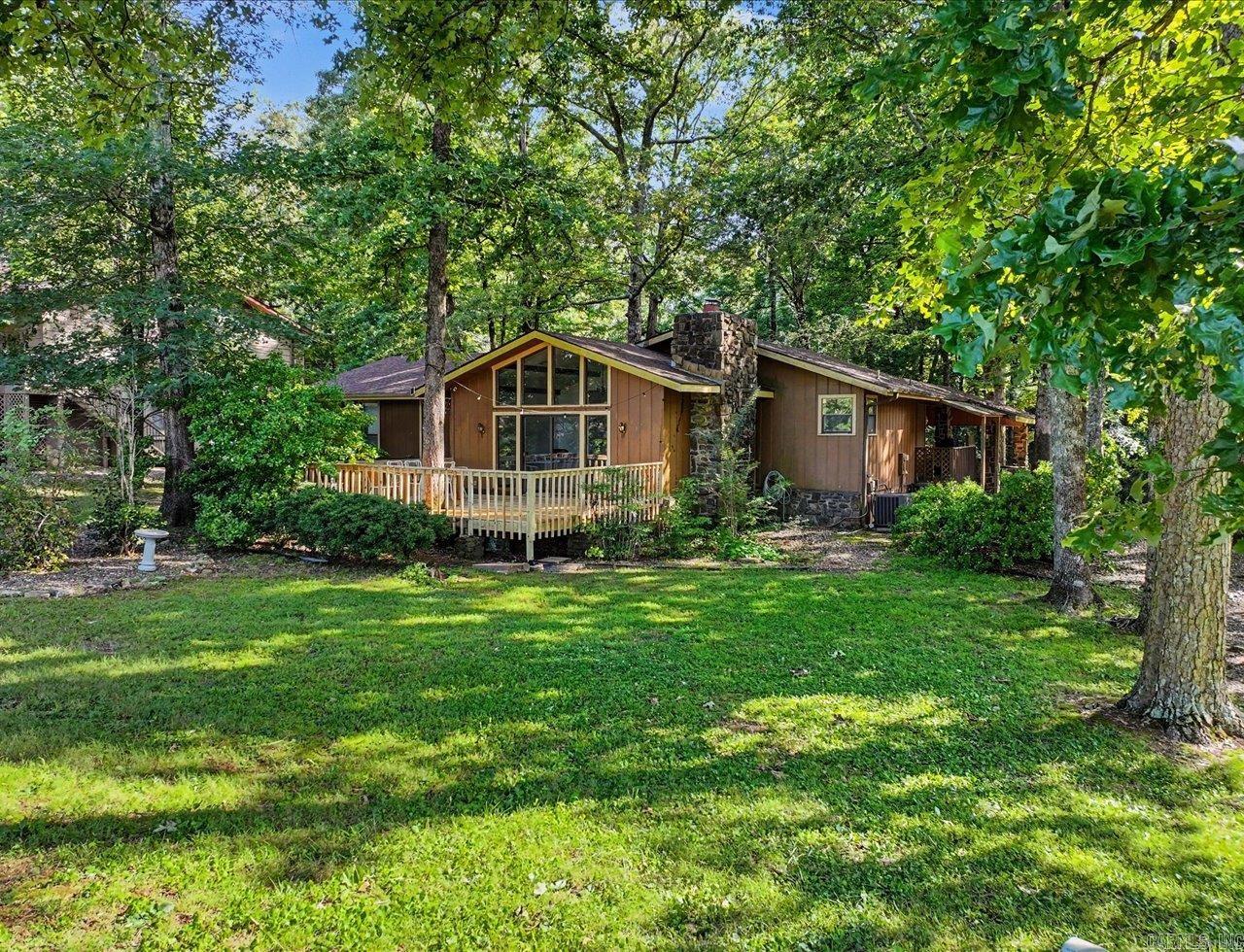 Golf course living on the 16th hole of DeSoto Golf Course! This 4-bedroom, 2-bath ranch-style home offers beautiful fairway views and a flexible layout ideal for a primary residence, vacation home, or investment property. The spacious living room features a vaulted ceiling, wood-burning fireplace, built-in shelving, and large windows that fill the home with natural light. The functional floor plan provides plenty of space for family and guests, while the golf course setting creates a peaceful backdrop for everyday living.  Conveniently located near the West Gate of Hot Springs Village, you'll enjoy easy access to golf, lakes, restaurants, shopping, and community amenities. Currently operating as an active short-term rental, this property offers excellent income potential. Most furnishings are negotiable, making it easy to continue as a vacation rental or move right in. Whether you're looking for a full-time home, weekend retreat, or investment opportunity, this golf course property combines location, convenience, and scenic surroundings in one attractive package.