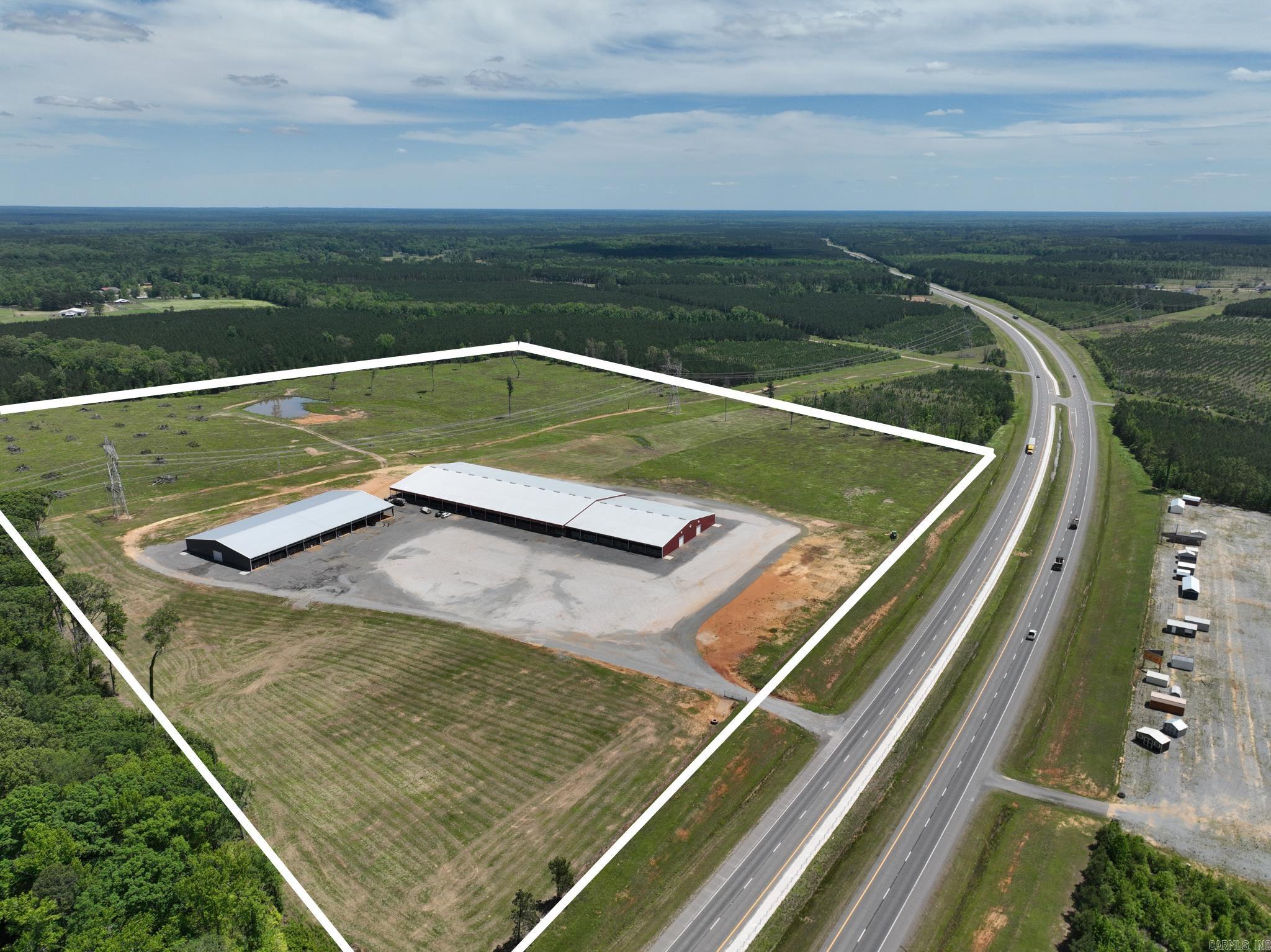 Premier rodeo and event facility offering approximately 91,000± SF under roof with extensive infrastructure for livestock events, equestrian use, and large-scale gatherings. The property features a 150’ x 300’ main red arena equipped with 3 Big Ass Fans.  Improvements include 175 total stalls (all pre-bedded), a 140’ x 150’ covered stall barn with 100 stalls, and a separate gray barn with 75 stalls and an attached 100’ x 120’ covered warm-up arena. Additional livestock amenities include 18 covered holding pens with room for expansion.  The property also includes 64 RV hookups (30 & 50 amp), ample parking, and two additional outbuildings. Interior improvements feature an 18’ x 30’ seating/stage area, an approximately 1,000 SF heated and cooled lounge with bar overlooking the arena, and a 400 SF heated and cooled announcer/office suite upstairs