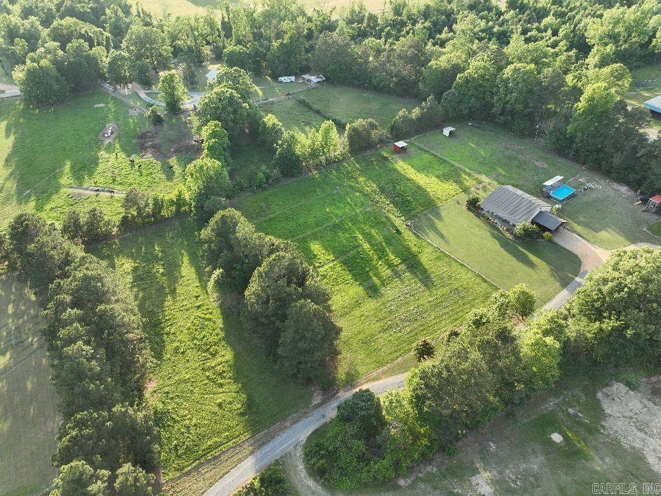 Sitting on 6 well-maintained acres, this red iron barndominium was built with durability, efficiency, and everyday living in mind. The home features a custom interior with wood siding and a one-of-a-kind iron staircase. The downstairs layout is open and practical, with the master suite on the main level, complete with a X-large walk-in closet, office space, and easy access to one of two laundry areas.  Upstairs, you’ll find two large bedrooms, each with its own private loft area that works well for studying, relaxing, or extra storage. There’s also a full bathroom and a wideopen space that can be used for entertainment, a second living area, or a place for the kids to hang out. The home is built with 6-inch spray foam and closed cell in the ceiling, making it efficient and easy to heat and cool year-round. Outside, the setup is ready for both work and recreation. A breezeway runs the full length of the home, connecting to two horse stalls with water and electricity already in place. The property is set up for rotational grazing with multiple fenced paddocks, all tied together with high-output electric fencing.