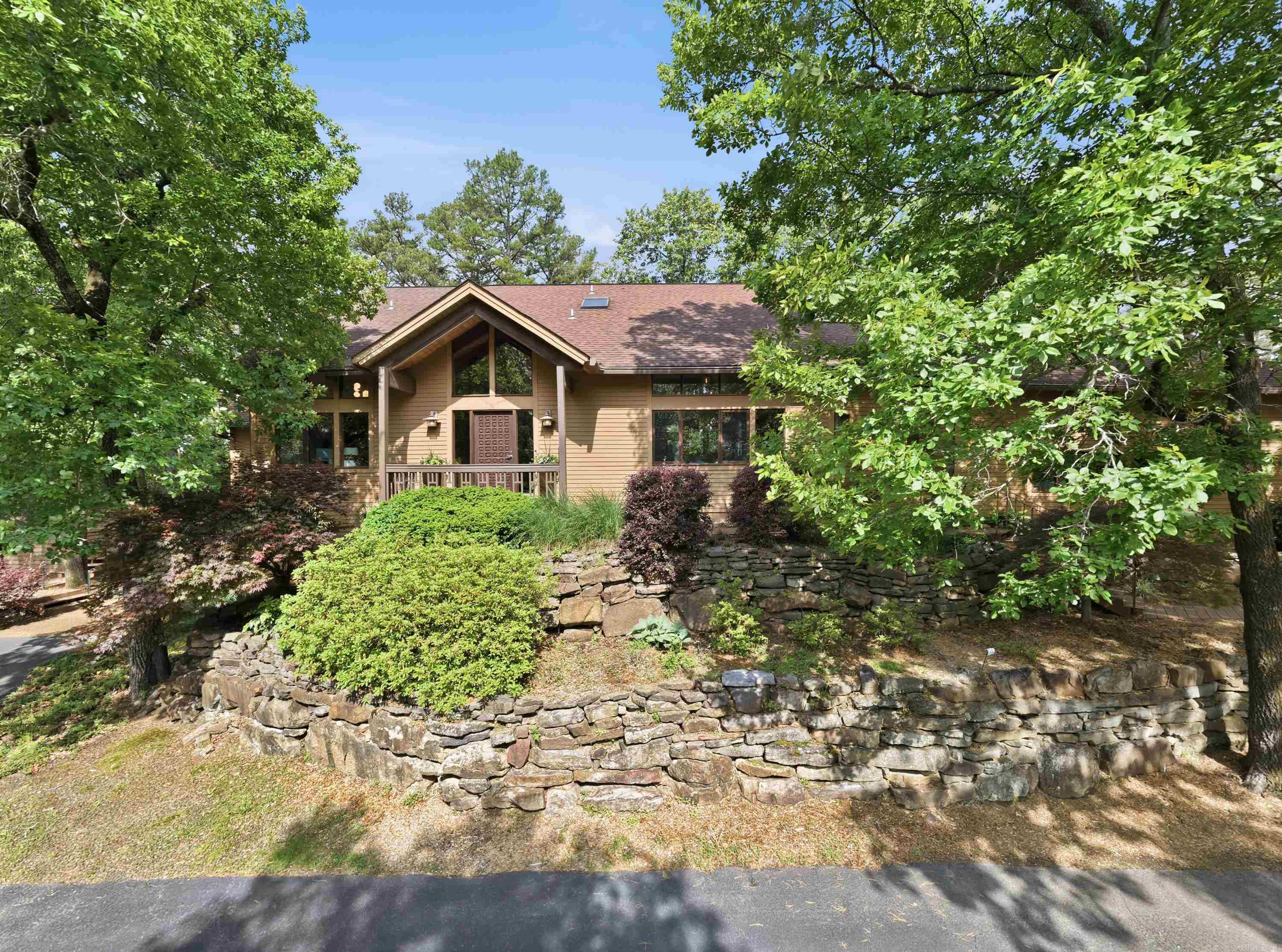 Nestled above the shoreline of Greers Ferry Lake, this stunning lakefront retreat embodies timeless elegance and a serene lake view. Thoughtfully crafted with mahogany beams enduring style, the home features spacious living areas filled with natural light, soaring ceilings and expansive windows. The main living areas offer a warm yet elegant ambiance, while the well-appointed kitchen provides beauty and function for gathering with family and guests. The fully finished basement expands the living space, offering endless possibilities for recreation, in-law quarters, hosting or a private getaway within the home. CLOSET SPACE galore. Office is complete with built ins.  This home also includes a detached 2 car garage for all types of storage. This home is a must see!! This home would be the perfect house on Greers Ferry Lake! Call today for your private showing!