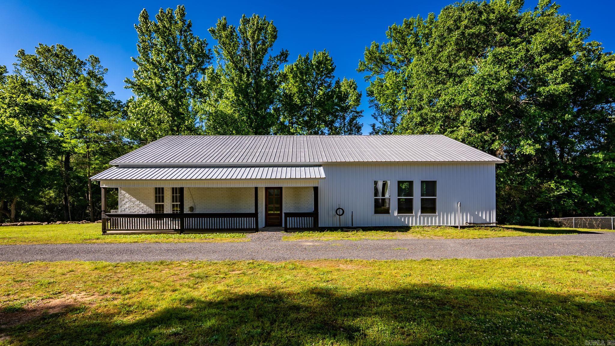 Fully renovated home in the heart of Clinton offering approx. 2,632 sq ft, 3 bedrooms, 3.5 bathrooms, and sitting on approx. 1.56 acres consisting of Tracts 1 & 2 per survey. This beautifully updated property features new paint, new flooring, updated lighting, new bathroom finishes, updated faucets, custom tile work, and modern finishes throughout. The spacious open-concept living, dining, and kitchen area offers 12 ft ceilings, abundant natural light, custom built-ins, and an electric fireplace. The kitchen features quartz countertops, oversized island with cooktop, farmhouse sink, floating wood shelves, custom cabinetry, tile backsplash, and stainless steel LG appliances. The private primary suite includes a spa-like bathroom with freestanding soaking tub, oversized tiled shower, double vanity, and walk-in closet. Additional features include a bright sunroom lined with oversized windows, covered porch, and large detached shop/garage.