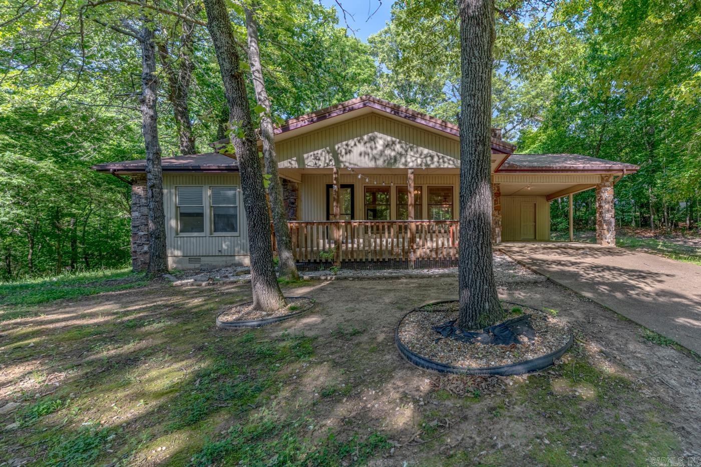 Welcome to Market 6 S Hileah Trce in Cherokee Village, AR within the Highland School District. Situated on a 0.30 +/- acre level lot at the end of a cul-de-sac and located 1 block from Lake Thunderbird is a ranch style home offering 1,176 sf of well laid out living space. The exterior is wrapped in wood & stone, topped w/ a metal roof, and accented by a covered front porch, attached carport, patio area, outside storage/work area, mature shade trees, and wooded backyard views. The interior holds 2 bedrooms and 2 full bathrooms w/ laminate flooring throughout, spacious living area anchored by a lovely native stone wood burning fireplace, kitchen/dining combo featuring abundant cabinetry, electric range, dishwasher, and microwave, oversized primary suite w/ full private bath, and dedicated laundry room offering additional storage space. You'll love the peaceful wooded backdrop, nearby lake access, and all the amenities Cherokee Village has to offer including: 7 lakes, South Fork Spring River, golf courses, marina, swimming pool, tennis court, playgrounds, and fitness/bike trails. Call today to schedule your tour and make this house your home or home away from home.
