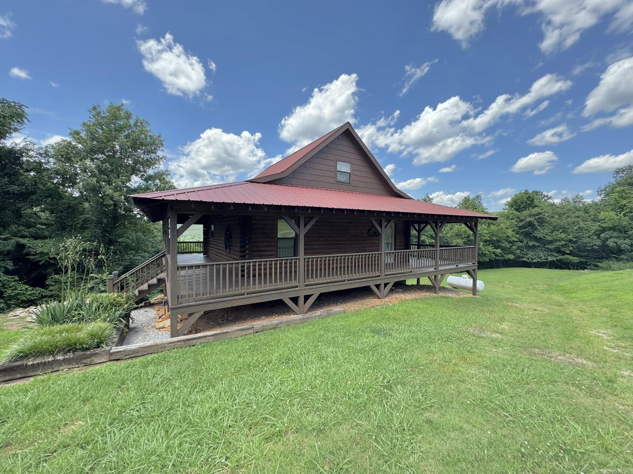 Endless Possibilities in Mountain View, Arkansas! This spacious 3-story home offers flexibility, functionality, and stunning views—perfect for full-time living, multi-generational use, or as an income-producing investment. Each floor features its own bedroom and full bathroom, offering privacy and convenience throughout.  The main level boasts an open-concept living room and kitchen with direct access to a scenic deck—ideal for entertaining or relaxing. The upper level includes a private suite with full bath and elevated views, while the walk-out basement features a third bedroom, full bath, laundry area, storm shelter/storage room, and a convenient kitchenette with cookstove and second refrigerator.  With indoor and separate outdoor basement access, this space is perfect for guests, short-term rentals, or extended stays. Enjoy both upper and lower decks to take in the breathtaking views of the Ozarks.  Whether you're looking for a peaceful place to call home or a great short-term rental opportunity near downtown Mountain View, this one is worth a look!