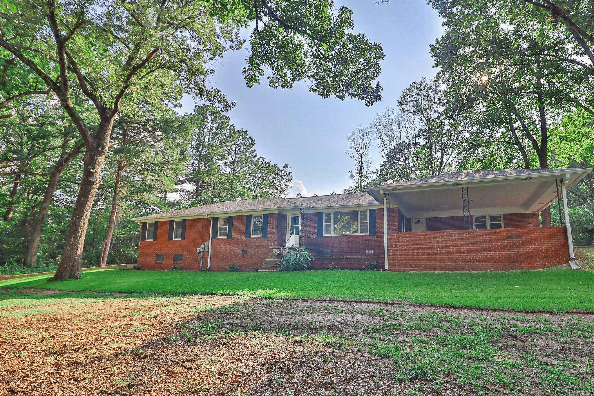 Located inside the Jonesboro city limits and just inside the bypass, 2711 Wood Street offers a rare combination of privacy, acreage, and convenience. Sitting on approximately 2.11 acres +/-, this property features mature oak trees, flowering dogwoods, and a winding driveway that gives it a true country feel while still being close to everything Jonesboro has to offer. The home has been fully remodeled with updates including a new roof, HVAC, cabinets, countertops, fixtures, flooring, and paint. It offers approximately 2,393 sq ft of living space, including a finished walk-out basement, plus a finished sunroom off the main living area. Inside, you'll find a functional layout with a spacious kitchen, den with fireplace, 3 bedrooms, and 2.5 baths. Laundry is available on the main level, with additional hookups in the basement. The basement also provides added flexibility and a solid option during storm season. Exterior features include an all-brick design and a large attached double carport. Properties like this acreage inside the city, fully updated, and move-in ready don't come along often.
