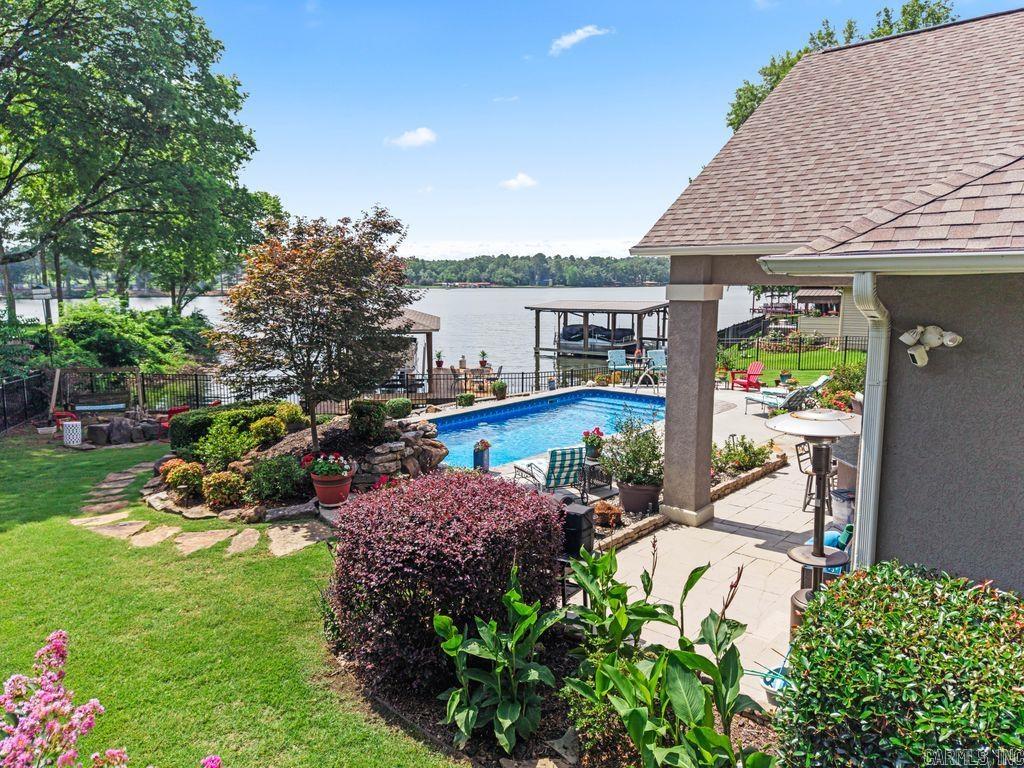 Beautiful Lake Hamilton home with all of the amenities! Salt water pool with new liner and new heater, beautiful waterfall. New HVAC 2025, new roof 2024, new garage door 2024. Extravagant landscaping. Outdoor kitchen with sink, grill, fridge. Perfect oasis for entertaining. Conveniently located to medical facilities, shopping, and restaurants. Each guest bedroom has its own private bath. Coffee bar between guests' rooms with fridge and wet bar. Great area upstairs: sitting area, built-in bunk beds, full bathroom. Butler's pantry area has sink and fridge.