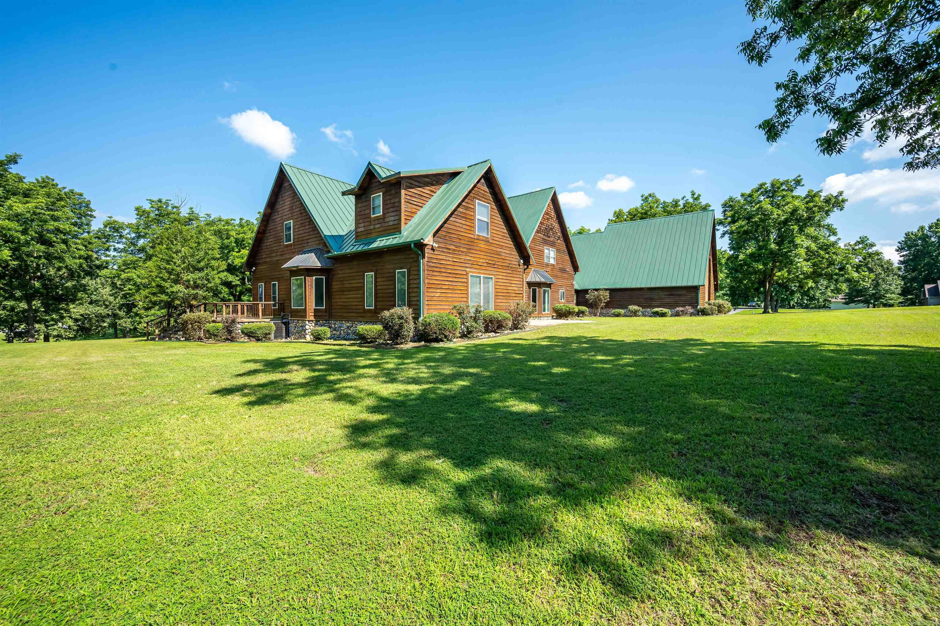 Experience luxury country living with this stunning lodge-style home situated on 3.09 beautifully maintained acres. Offering over 5,900 sq ft, this exceptional property features 4 bedrooms, 4.5 bathrooms, multiple living areas, and a layout designed for comfort and entertaining. The spacious kitchen opens to two living rooms and two dining areas filled with natural light. The home offers two primary suites, one upstairs and one downstairs, plus flexible bonus space ideal for an office, media room, or play area. A beautiful catwalk overlooks the main living area below. Additional features include oversized bathrooms, walk-in closets, a safe room, and a massive garage complete with an indoor basketball court. The impressive 32x50 shop provides endless storage or workspace options. Enjoy over 1,000 sq ft of covered porch and patio space, beautifully manicured acreage, and room to relax or play. A truly one-of-a-kind property. Call today to schedule your showing.