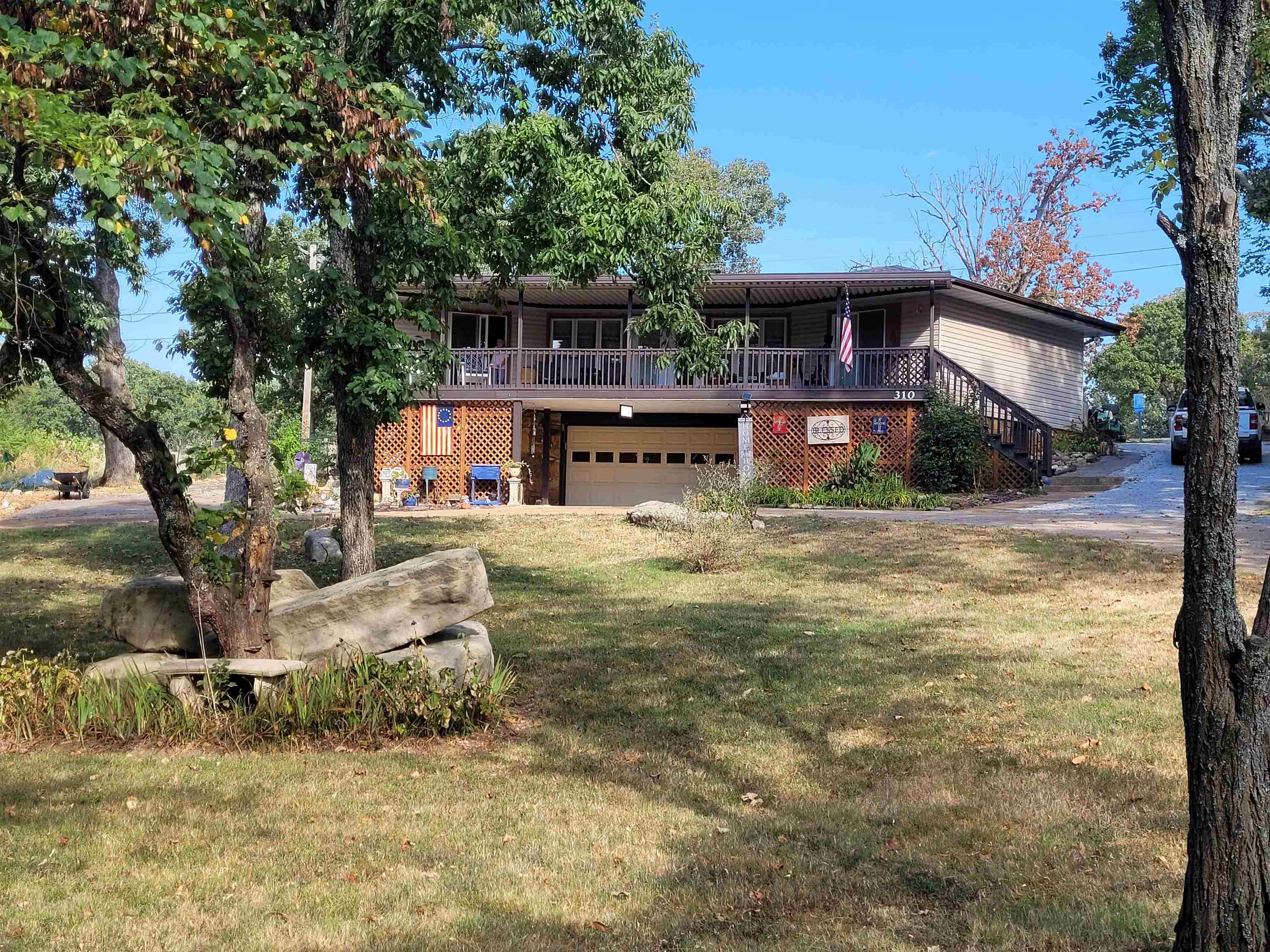 Nestled in the picturesque community of Horseshoe Bend, Arkansas, this stunning home offers a tranquil lifestyle. Located on the 13th hole of Turkey Mountain Golf Course, the property provides beautiful views and a golfer's paradise right in your backyard. The home features a large open-concept living area with a vaulted ceiling and a towering fireplace, creating an inviting and spacious atmosphere. Recent updates have enhanced the home's beauty and functionality like flooring, deck and ramp, shelving, and chain link fencing, just to name a few. An additional room with a separate exterior door, currently used as a craft room, offers the flexibility to be converted into a third bedroom. The large two-car garage provides ample space for vehicles and storage. It is heated/cooled and has been previously used as a man cave. The exterior of the property is equally impressive, with meticulously maintained landscaping that adds to its curb appeal. A significant amount of under house storage space offers practical solutions for all your organizational needs. This home combines elegant living with a prime location, making it a true gem in Horseshoe Bend.