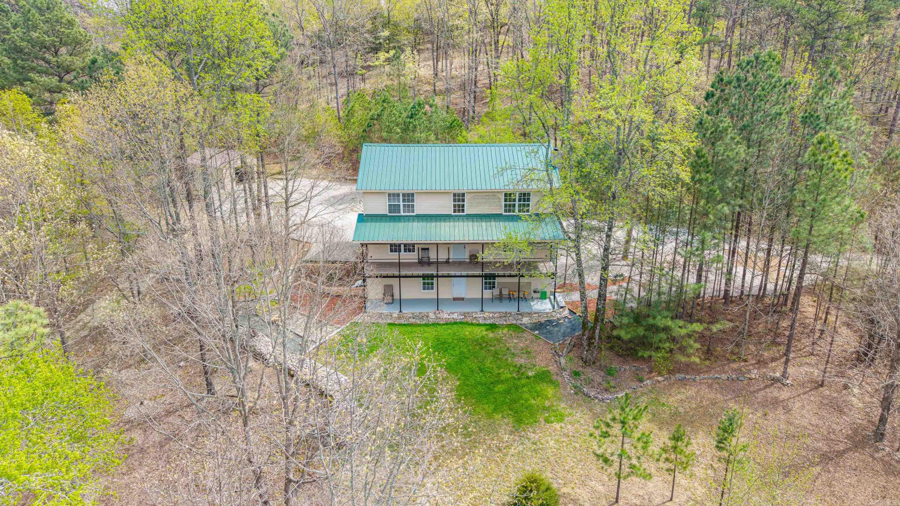 This stunning 5-bedroom, 3-bath home offers 3,528 sq ft of space, privacy, and breathtaking views you’ll never tire of. Start your mornings on the covered porch with coffee, soaking in peaceful mountain sunrises. Inside, natural light fills the home, highlighting rich hardwood floors, a cozy wood-burning fireplace, and open living areas designed for comfort and connection. The kitchen features beautiful cabinetry, ample counter space, and a central island perfect for gathering. Upstairs, a balcony overlooks the main living area, along with a versatile bonus space ideal for an office, playroom, or game room. The fully finished basement expands your options with extra rooms and a full bath—perfect for a mother-in-law suite or Airbnb. Outside, enjoy open land, mature trees, custom rock work, and a storage shop. Just minutes from Hot Springs, this property is a perfect blend of space, privacy, and opportunity. Whether you're seeking a peaceful retreat, multi-generational living, or income potential, this property delivers unmatched flexibility and charm while still offering convenient access to dining, shopping, and entertainment nearby. Schedule your private tour today and see it!!