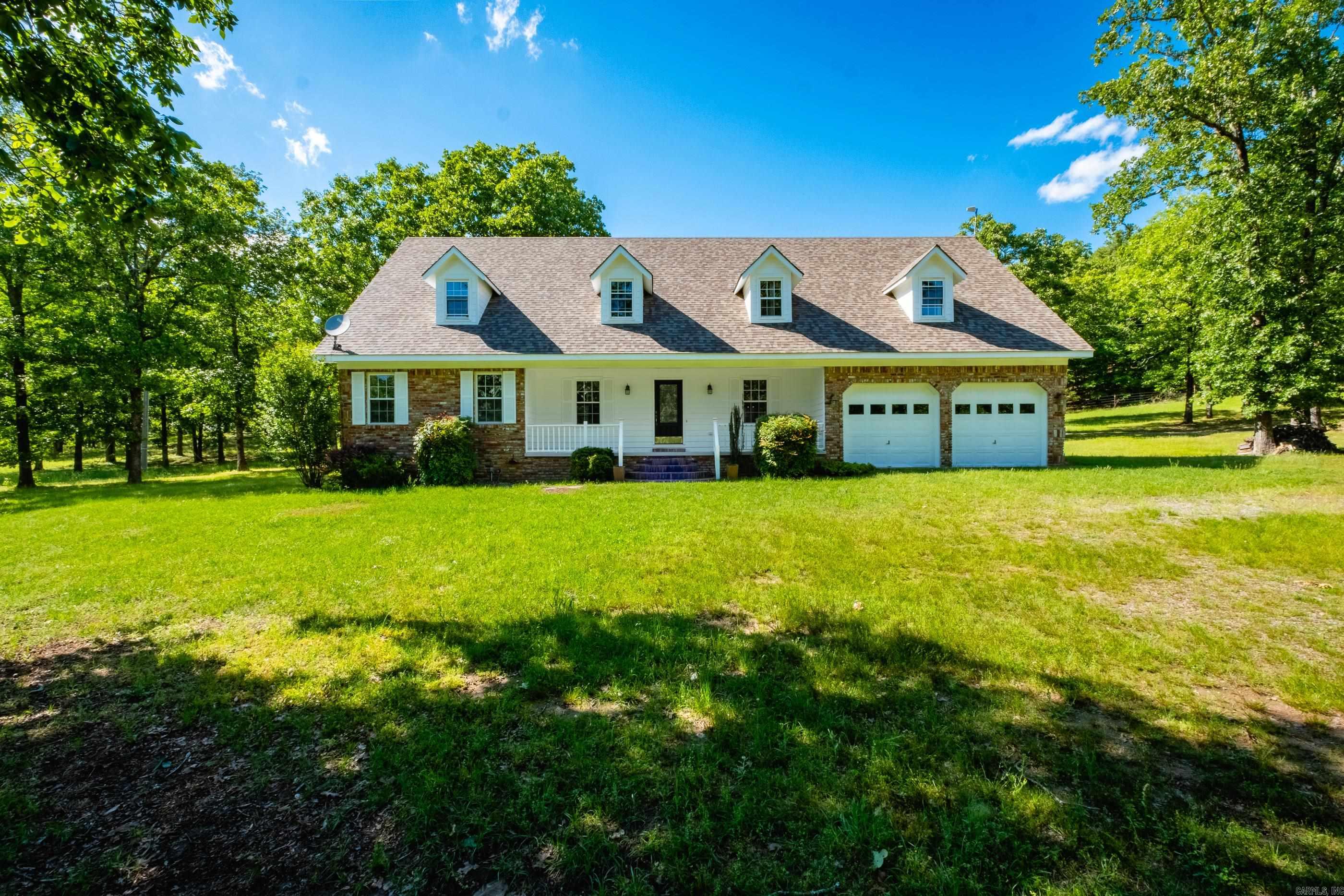Set on approximately 7.5 scenic acres, this unique estate offers peaceful country living with a stocked pond, guest house, shop, and greenhouse. The main home includes five bedrooms and three full baths with a functional layout ideal for everyday living. The primary suite is on the main level along with two full baths, a formal dining room, large laundry room, and beautiful pine flooring throughout most of the home. The kitchen features a commercial-grade refrigerator, built-in espresso maker, double ovens, ample cabinetry, and generous prep space. Upstairs are four additional bedrooms, a full bath, an office nook, and large walk-in closets. A separate studio-style guest house provides a bedroom, full kitchen, full bath, and laundry area—perfect for guests, in-laws, or rental income. Enjoy open, private acreage and peaceful views already established for you. The property is on city water and has a private well with filtration. The property line extends approximately 20 feet beyond the back fence. *Property is in an Estate. No disclosure, sold AS IS.  Acreage to the left of the home is available-See agent remarks for more details!