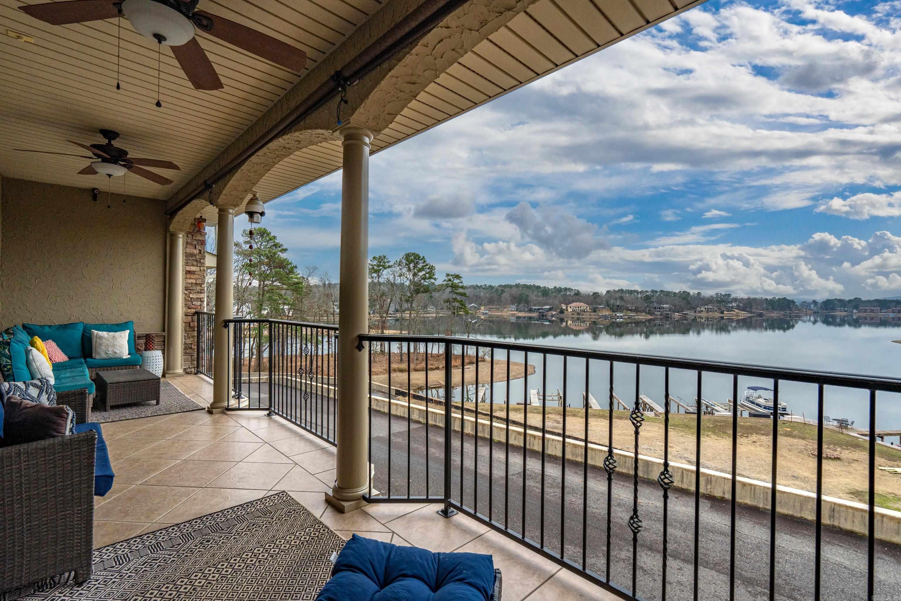 Attention Sunset Lovers! This lake condo sits on a wide open cove where the water catches the last light of day. Floor-to-ceiling windowsframe the sunset as it drifts across the lake, washing the living space in warm golds and soft pinks. Outside, the surface of the waterturns glassy, reflecting the sky so clearly it feels like the room extends straight into the distance. The balcony invites you to step out asthe sun lowers, the air cooling just enough to be comfortable. Evenings here move slowly, marked by the sound of water against theshore and the fading glow of color over the lake, making the condo feel like a quiet retreat from everything else. This two-story condo isthoughtfully designed to balance privacy with comfortable shared living. The main living areas are located upstairs including a primary bedroom en-suite, while downstairs are 2 additional bedrooms and bathroom.  This lakefront condo offering beautiful sunset views and a private boat slip, combining effortless lake access with a peaceful, scenic setting, is perfect for relaxed waterfront living or weekend escapes.
