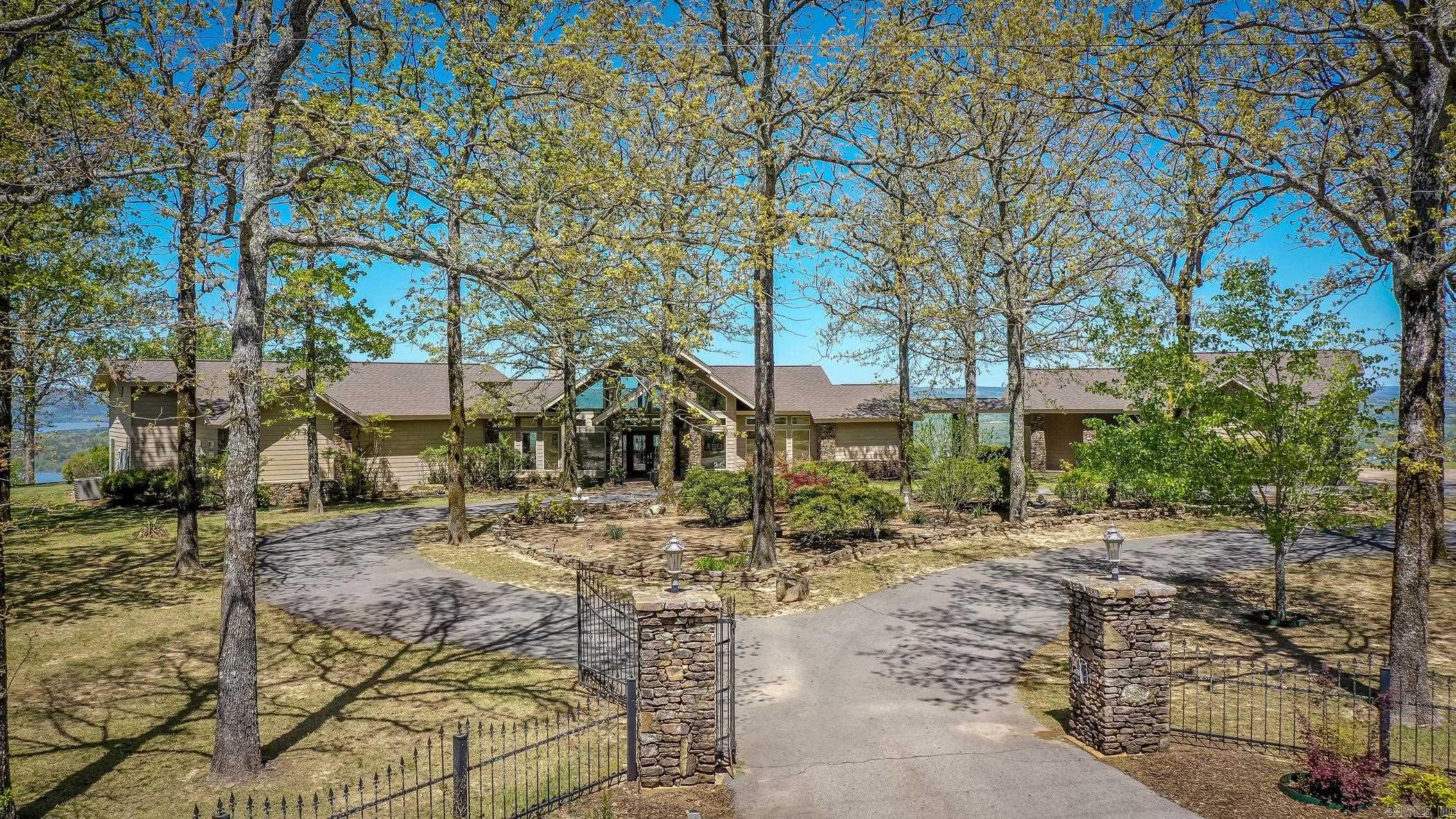 This is a rare opportunity to own a truly one-of-a-kind property, offered to the market for the very first time. Thoughtfully custom-built, this home is perfectly positioned on the bluff to capture breathtaking panoramic views from every room, including stunning sights of the Narrows Bridge, Greers Ferry, and beyond. Located within a gated subdivision, the property offers both privacy and peace of mind. The home is designed for convenient single-level living, featuring low-maintenance finishes. Generac generate backup for essential things in home and garage doors. A breezeway seamlessly connects the main residence, guest apartment, and garage with total under roof sqft over 5,900. The main home includes 4 bed/2.5 bath. The quest house offers full living area, kitchen, bedroom and full bath. A washer hookup is also available in the garage for added flexibility. The home is serviced by city water but does have a well over 400 feet deep, suitable for irrigation or gardening needs. Properties of this caliber and uniqueness are seldom available and must be experienced in person to fully appreciate its exceptional setting and design. Agents, please see all remarks.
