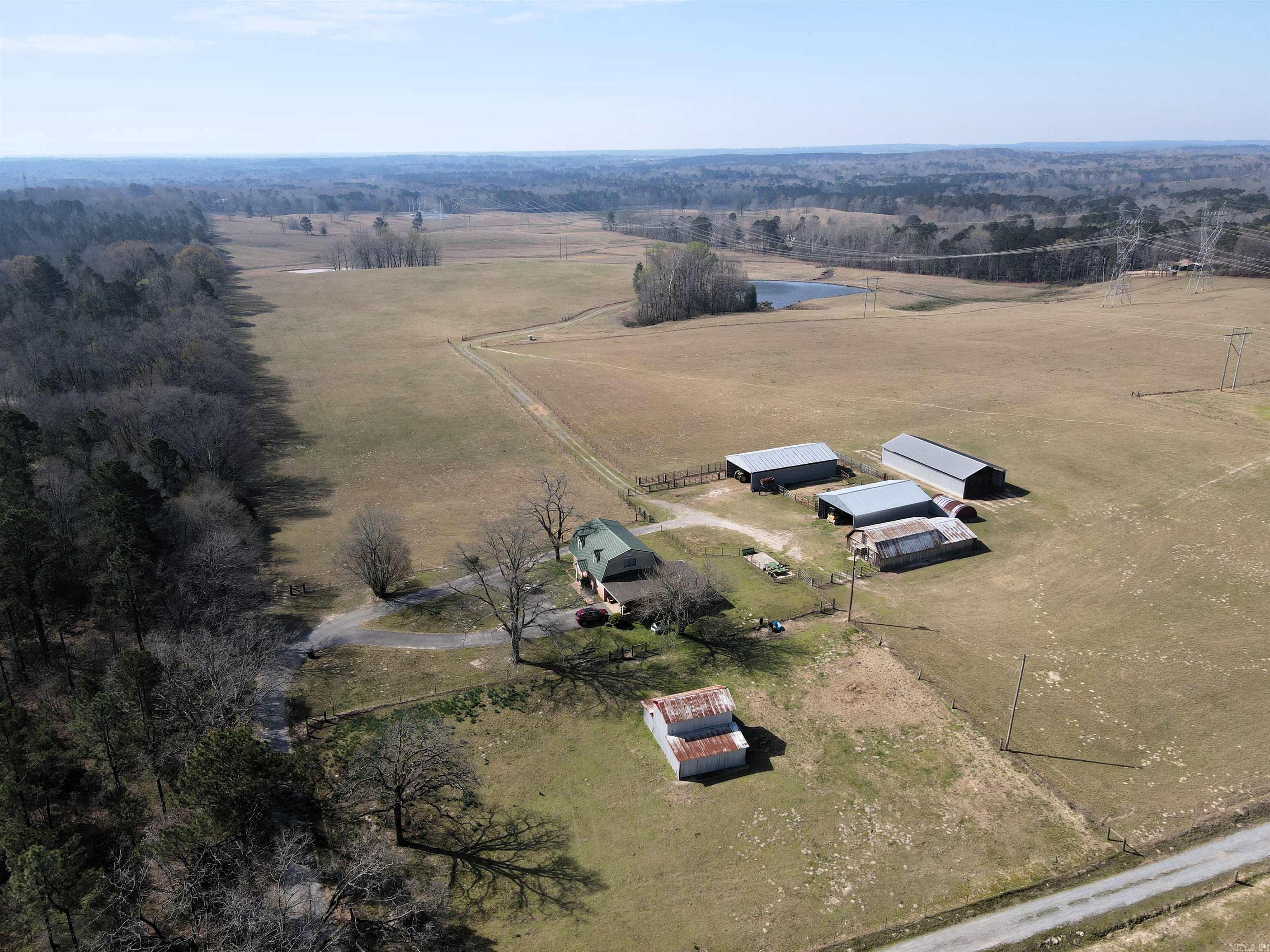 Spanning approx 175 acres of productive pasture with an additional 100 acres of mature mixed timber, this exceptional property offers the perfect blend of agricultural functionality & natural beauty. The land is thoughtfully laid out with well-maintained grazing & hay pastures, supported by full perimeter fencing & cross-fencing for efficient livestock management. Multiple ponds & springs are scattered throughout, providing reliable water sources for the current cattle operation while also enhancing the property’s scenic appeal. @ the heart of the property sits a 2,397 sq ft home, ideal for comfortable country living with room to grow. Supporting the cattle operation are 4 substantial barns, 2 30x60, a 36x50, &a 36x70, offering ample space for equipment storage, hay, or livestock needs. Multiple access points make navigating the property convenient & practical, whether for daily farm use or subdividing for future development opportunities. Located just 6 miles from the Little Rock city limits & only 4 miles to Bryant, this property delivers the rare combination of privacy and accessibility. Situated outside city limits with the option to subdivide, it presents incredible potential
