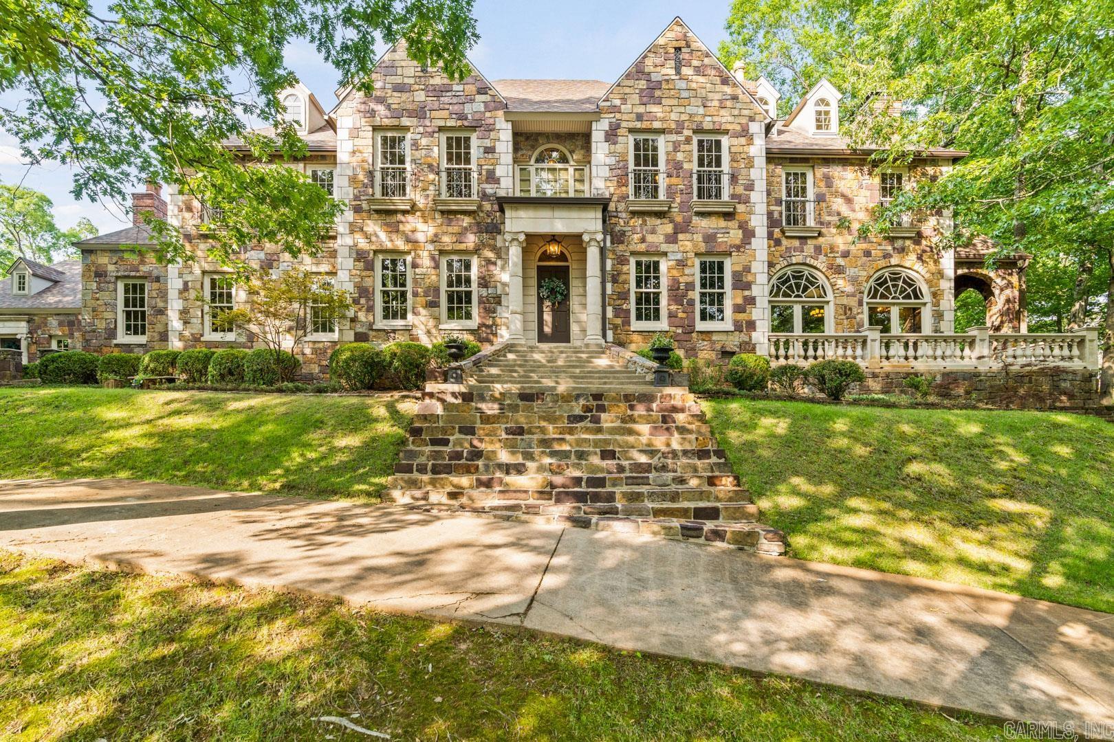 Magnificent English Estate in the country with beautiful views of surrounding property! Yet just minutes from the Promenade. Gorgeous stone exterior home with attached two car garage with exercise room above, plus a separate 2167 sq ft heat and cooled 9 car garage / shop. Charming 2 story stone fully functioning guesthouse all on 5+ acres on the western edge of town in a picturesque rolling hill setting with creek. Exquisite family home that has stunning imported woodwork and built ins throughout. Generator, 5 Fireplaces, hardwoods, gorgeous stone, tile and carpet floors with beautiful modern amenities.  Porches galore.  Recent updates include new hardwoods upstairs in hallway and primary bedroom and downstairs hardwoods refinished.  Fresh paint in the main house and the biggies....New roof on main house and nine car garage AND all new HVAC in all the buildings.  Gorgeous piece of property with a fabulous gate entering the property.   Make an appointment to come see this beauty.