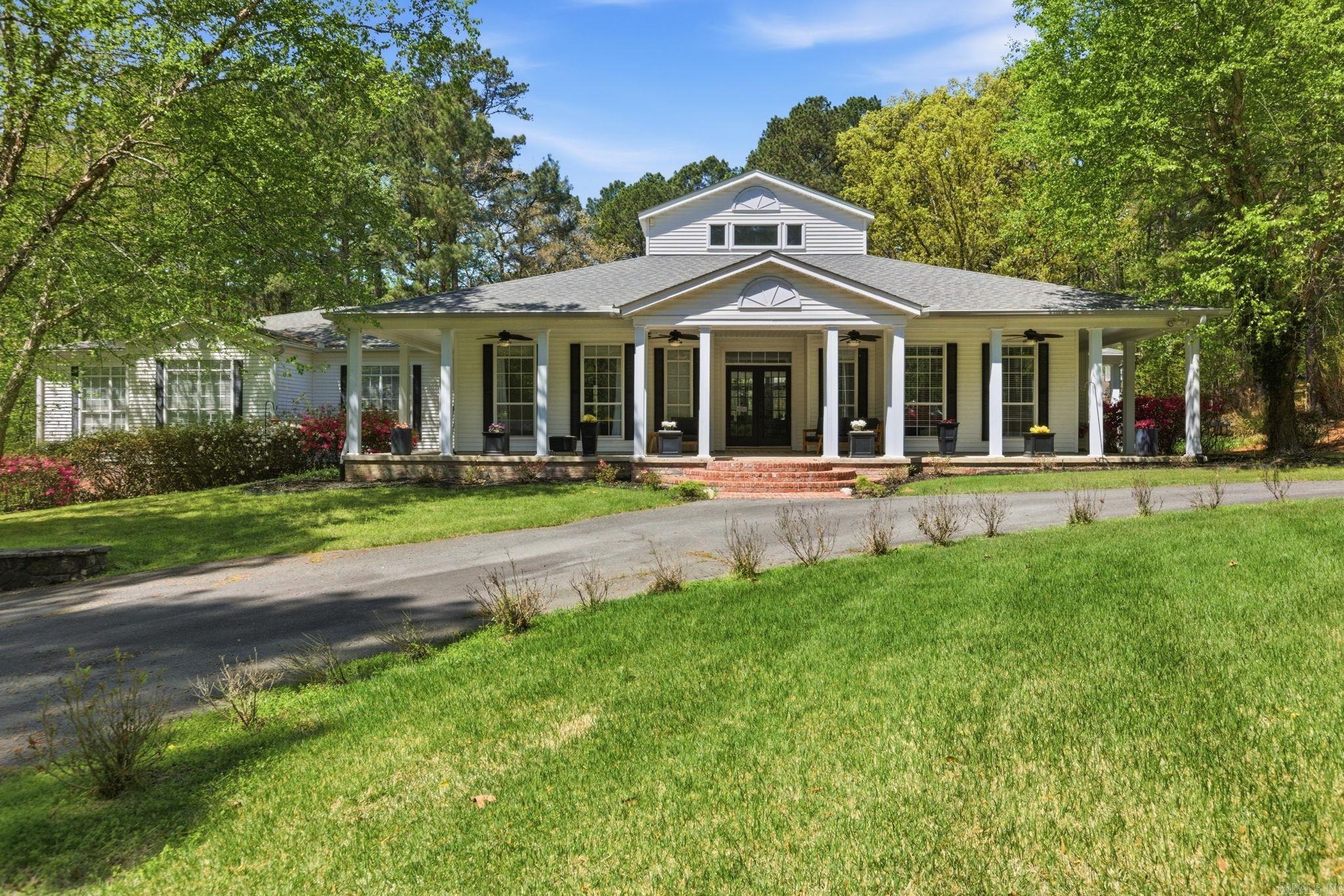 Privacy, elegance, and location come together on this estate set on over 6 wooded acres in the heart of Little Rock, where a gated entrance offers complete privacy and peaceful surroundings. This one level home offers 6 bedrooms, 5.5 baths, two primary suites, and a media room, all tucked away minutes from the Outlets and city access. Bathrooms have been beautifully renovated with new stone, hardware, and lighting throughout. The kitchen has been thoughtfully reimagined with painted cabinetry, new countertops, updated lighting, a coffee station, pantry, and a spacious island, all flowing into the family room with beautiful, vaulted ceilings and abundant natural light, creating an ideal space for entertaining and everyday living. Hardwood floors extend throughout the home, all bedrooms feature walk in closets, and the laundry/mud room adds function. Outside, the setting feels like a private resort with an inground pool, new gazebo, and deck overlooking the pool. The property also includes a 30x40 shop, and a newly added two car garage for the in-home gym makes this a 6-car garage, while the lawn sprinkler system adds everyday ease. Agents see remarks for additional property.