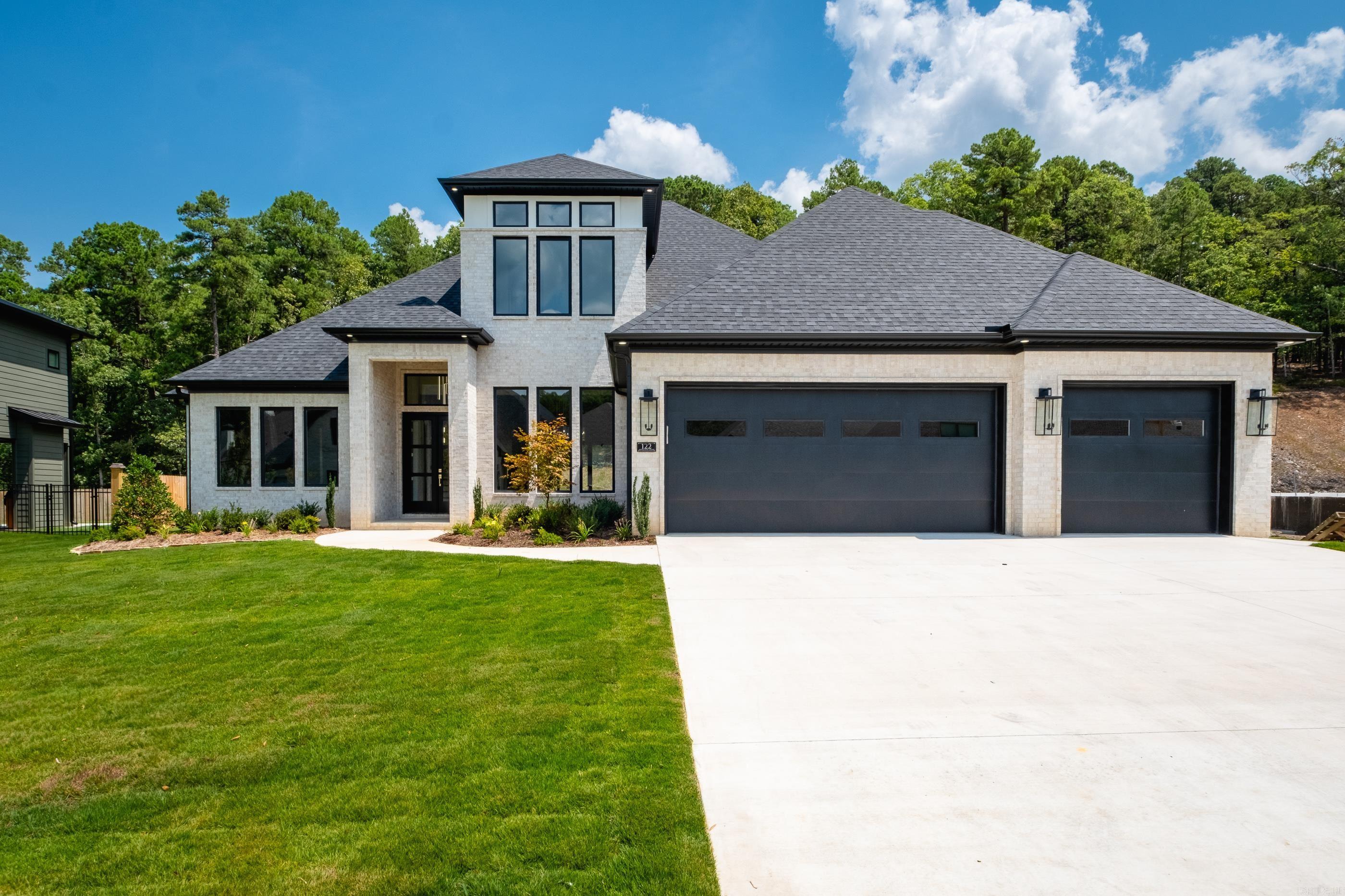 Welcome to 122 Abington Drive, a stunning light-brick home with bold black windows, striking landscaping, & timeless curb appeal. Step through the grand black front doors with oversized windows & into a space filled with natural light, custom ceiling lighting, & an open floor plan designed for both comfort & entertaining. The heart of the home is the spacious kitchen, featuring double ovens, abundant cabinetry, a walk-in pantry, & built-in glass display cabinets. Timeless light fixtures & fans accent the home throughout, while custom built-ins add both character & functionality. The primary suite is a private retreat, complete with its own fireplace, a spa-like bathroom with a huge walk-in shower, a relaxing soaker tub & split vanities with elegant gold finishes. For added convenience, the primary connects directly to the laundry & mudroom. Downstairs, you’ll also find a Jack & Jill bathroom shared by two bedrooms & an additional bedroom with its own private bathroom. Upstairs, in addition to a bedroom and full bath, a large bonus room provides the perfect space for a media room or playroom. Outdoor living is a true highlight with a patio, fireplace & grill fully fenced for privacy
