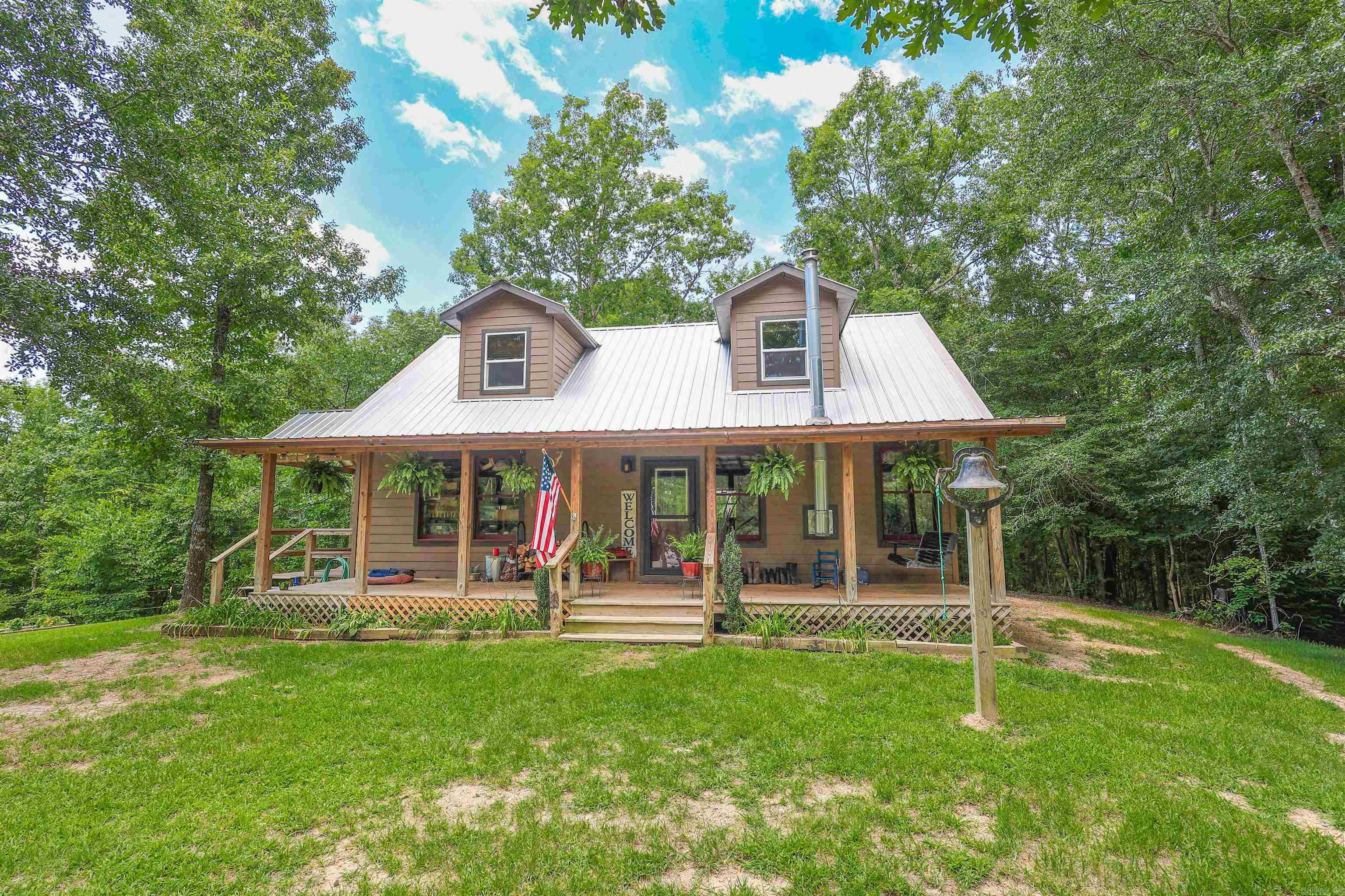 Escape to the beauty of the Ouachita Mountains with this custom 3-bedroom, 2-bath, two-story home situated on approximately 11.73 acres in Caddo Gap, Arkansas. Thoughtfully designed for country living, this property is ideal for those seeking a homestead, hobby farm, or a full-time residence that feels like an escape.  The home features warm wood finishes, an open-concept living area, a spacious kitchen with a large island, and a nice porch perfect for enjoying the surrounding scenery. Mini-split heating and cooling units, approximately two years old, provide modern comfort, while a water softener and whole-house filtration system enhance the well water.   Outside, you'll find raised garden beds, a chicken coop, an outbuilding with electricity, a creek, and beautiful mountain views. Located approx. 1 mile from the Caddo River.  Just minutes from the Ouachita National Forest and endless outdoor recreation. Glenwood's shops, restaurants, and schools are only a short drive away, while Lake Greeson, Lake Ouachita, and Crater of Diamonds State Park are all within easy driving distance.  Agents see remarks