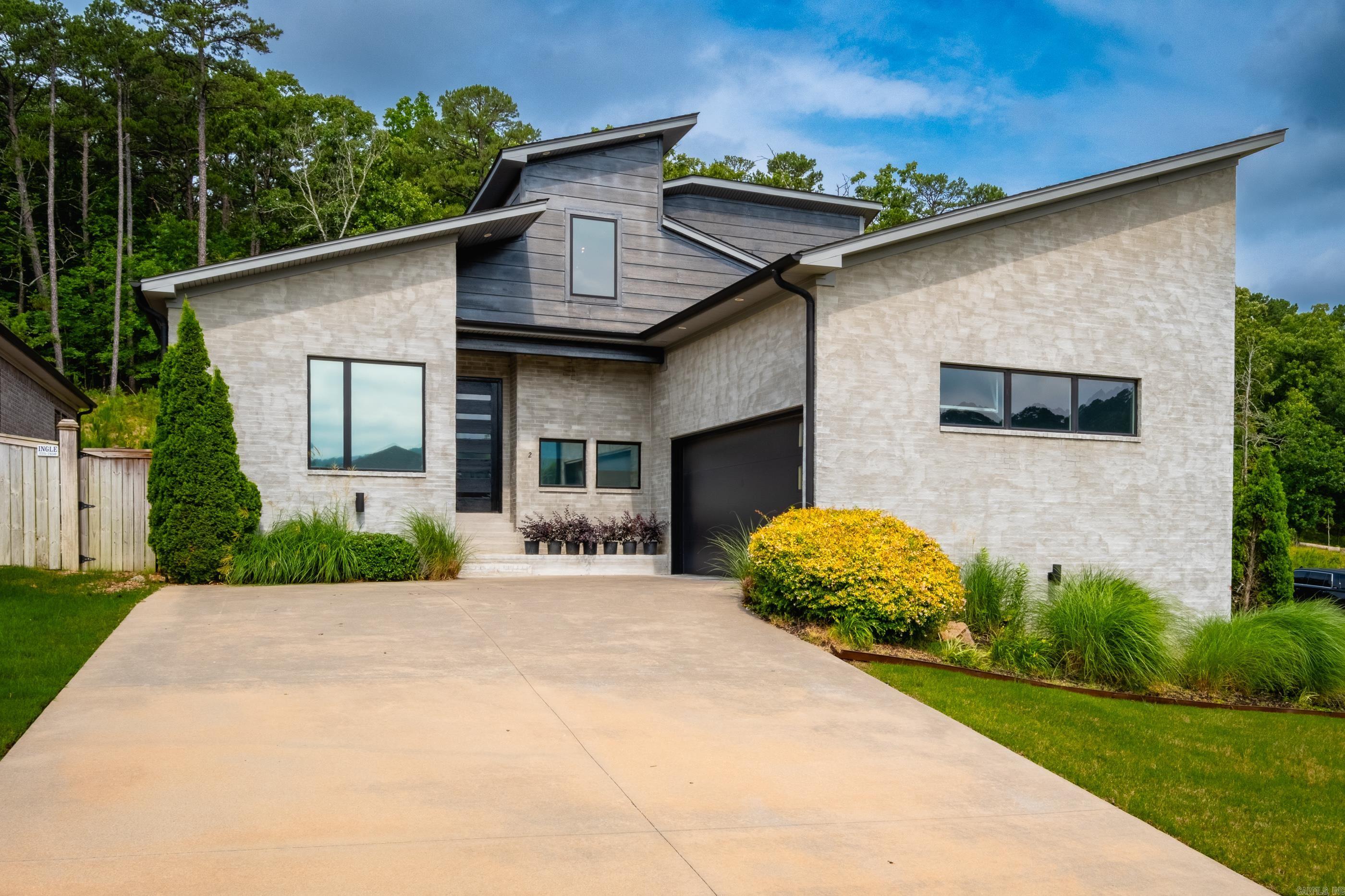 Exceptional quality and custom design define this stunning contemporary home situated on a desirable corner lot in the Village at Ison Creek off Pinnacle Valley Road. Enjoy beautiful mountain views and the privacy of wooded greenspace behind the property, creating a peaceful retreat. This thoughtfully designed home features four bedrooms, three full baths, perfect for any lifestyle. The fourth bedroom, complete with an adjacent full bath, is ideal as a guest suite or private home office. The showpiece kitchen features handsome white oak-stained Cleaf cabinetry, premium finishes, and a hidden oversized walk-in pantry-you won't want to miss! Dramatic 12-foot sliding glass door leads to a large covered patio overlooking a perfectly sized flat backyard. Primary suite offers vaulted ceilings and a spa-inspired bath featuring a marble shower, soaking tub, double vanity and large closet with built-ins. Built with comfort and efficiency in mind, including fully encapsulated foam insulation for enhanced energy performance and year-round comfort. Abundant storage throughout and an oversized garage. Contemporary style, quality construction, in a highly desirable location. (see agent remarks)