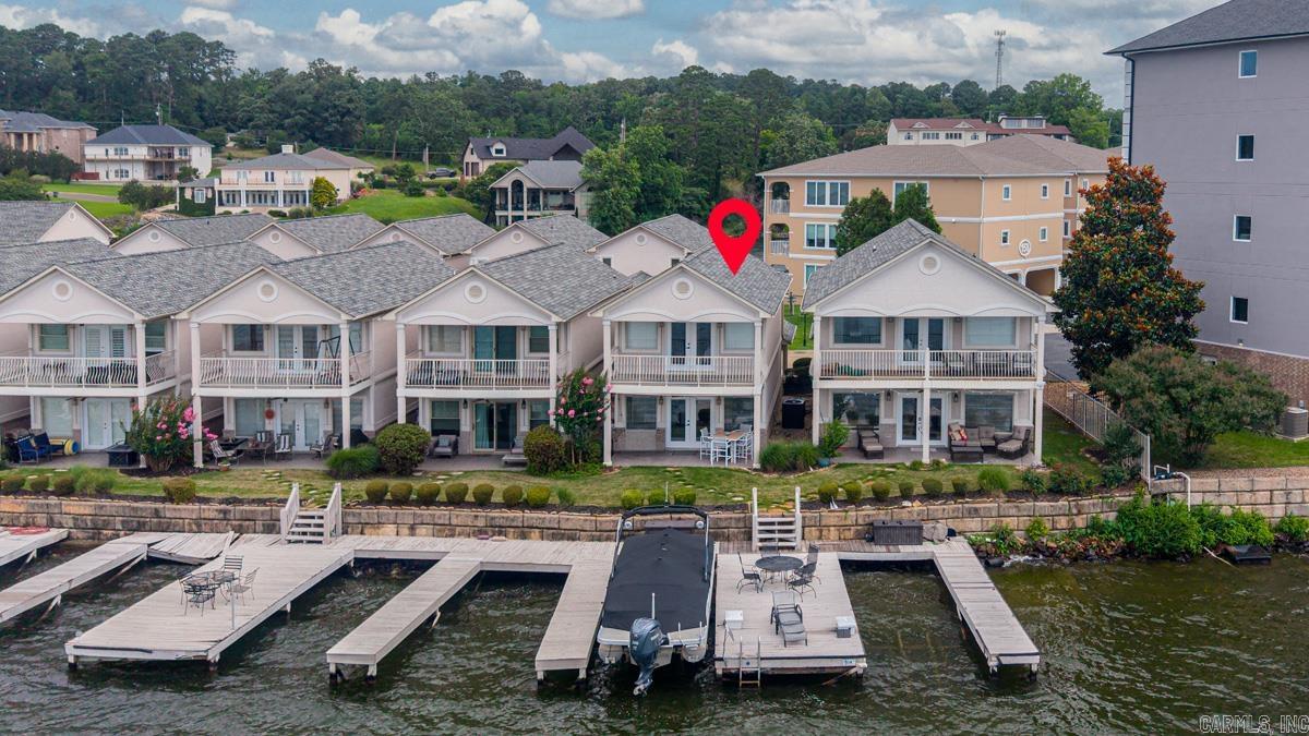 Breathtaking main-channel sunsets await at this premier Lake Hamilton totally updated townhome.   Located in the highly desirable gated Villa Point community. Perfectly designed for year-round entertaining.  This lakeside retreat features an expansive open floor plan that flows seamlessly from the entry foyer to a beautiful kitchen with breakfast bar, dining area, and spacious living room with a fireplace. Step directly onto your private waterfront covered patio to enjoy front-row views of holiday fireworks, or walk straight to your private boat dock equipped with a lift or relax on the deck. The upper level boasts two en-suite bedrooms, including a primary suite with a private balcony showcasing panoramic lake views. Complete with a two-car carport for convenient covered parking.   This fully updated sanctuary comes with all appliances included. Community pool. Move-in ready and close to all Hot Springs amenities—make this your dream lake home today!
