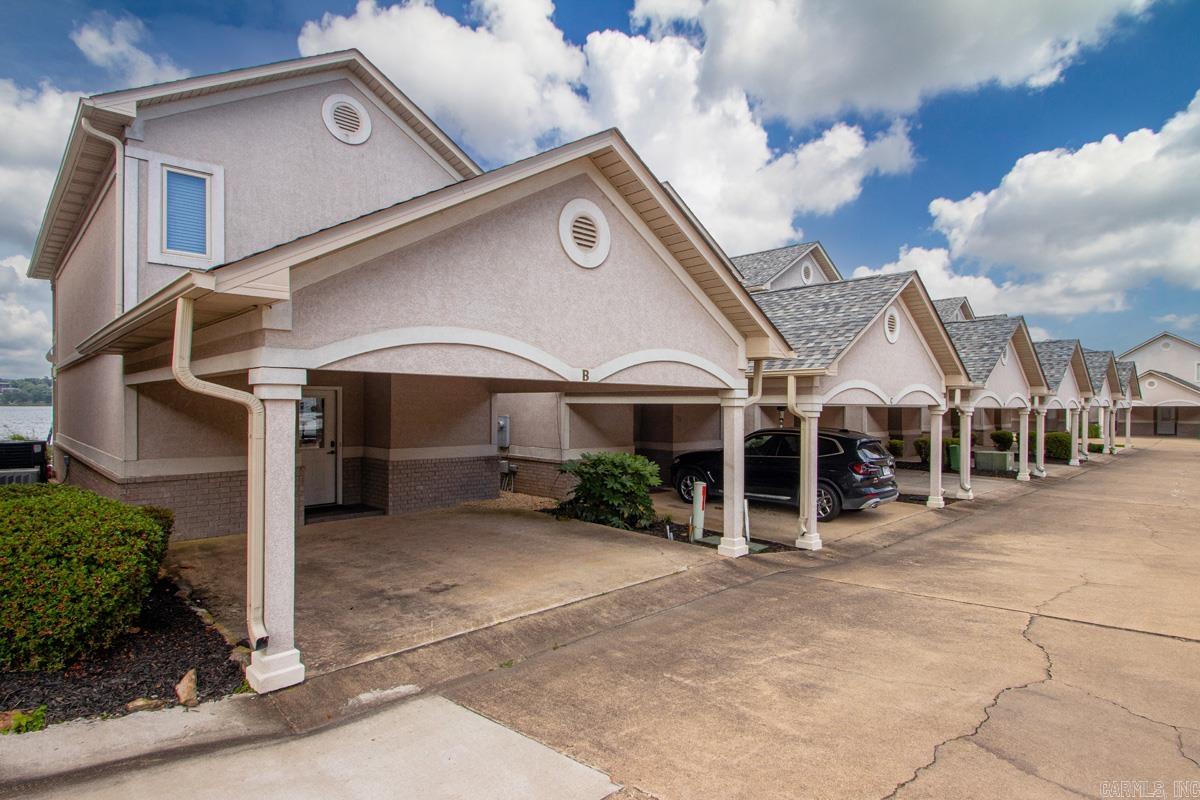 Breathtaking main-channel sunsets await at this premier Lake Hamilton totally updated townhome.   Located in the highly desirable gated Villa Point community. Perfectly designed for year-round entertaining.  This lakeside retreat features an expansive open floor plan that flows seamlessly from the entry foyer to a beautiful kitchen with breakfast bar, dining area, and spacious living room with a fireplace. Step directly onto your private waterfront covered patio to enjoy front-row views of holiday fireworks, or walk straight to your private boat dock equipped with a lift or relax on the deck. The upper level boasts two en-suite bedrooms, including a primary suite with a private balcony showcasing panoramic lake views. Complete with a two-car carport for convenient covered parking.   This fully updated sanctuary comes with all appliances included. Community pool. Move-in ready and close to all Hot Springs amenities—make this your dream lake home today!