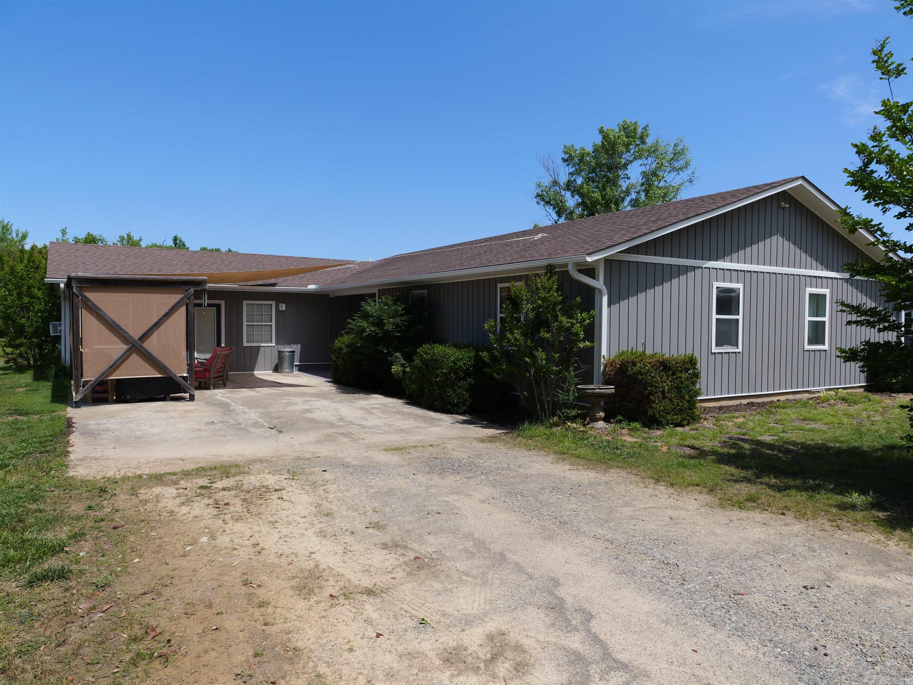 ACREAGE. Check out this newly remodeled light-filled home on approx 40 acres! House is designed with open floor plan and freshly remodeled inside and out with all the newest design choices. There is a 1300 Sq ft shop with 2 car bays and lots of room for tools and storage! Beside it is a covered open bldg to keep 2 tractors, etc... out of the elements. Lots of open space outdoors and timber and a pond. A must see on the old Wynn Stadium grounds!