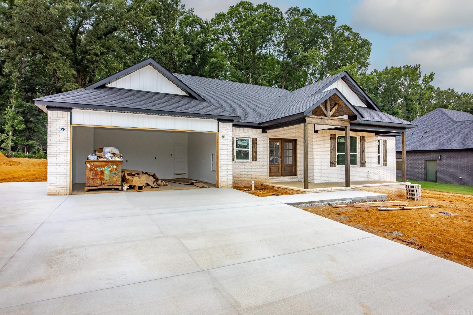 New construction home welcoming you in with a stunning stained beam in the large living room/kitchen and dining area.  Butler's panty(butcher block countertops) & an amazing Costco door.  Electric fireplace w/a live edge mantle, covered front porch & back patio. Added privacy with tree line at rear of property. Primary bedroom is enormous, bathroom has a large walk in tiled shower, double vanities and free standing tub, 11x8 closet with access to huge laundry room(hanging area & lots of storage) Extra bedrooms are all 12x12 in size. Ample storage throughout. Oversized garage with floored attic storage.