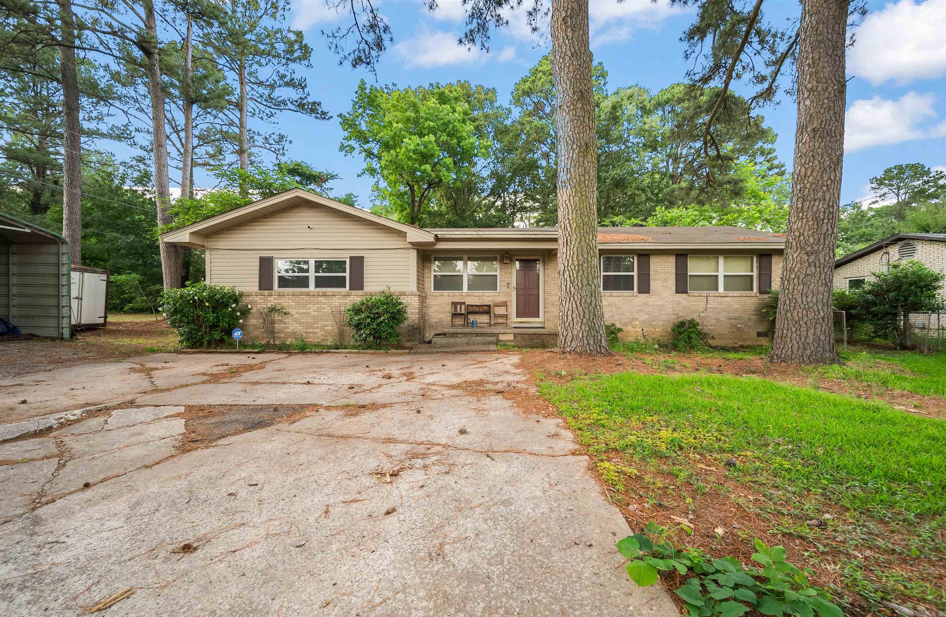 Nestled on a spacious double corner lot shaded by mature trees, this property is full of potential and ready for its next chapter. Whether you’re looking for a home to personalize, an investment opportunity, or a property with room to grow, this one offers endless possibilities. Inside, you’ll find 3 bedrooms, 1.5 bathrooms, two separate living areas, and a stunning rock fireplace that serves as the heart of the home. The flexible floor plan provides plenty of space for gathering, entertaining, or creating a dedicated office, playroom, or hobby space. While the home could benefit from some updates and TLC, its character and layout provide a solid foundation for your vision. Outside is where the possibilities truly expand. The oversized double lot offers abundant space beneath a canopy of mature trees, along with multiple metal-covered structures that could be utilized for storage, workshops, equipment parking, or potentially commercial purposes. With excellent visibility from the corner location and ample outdoor space, this property offers opportunities that are hard to find. Bring your ideas and imagination, this unique property is ready to become something special.