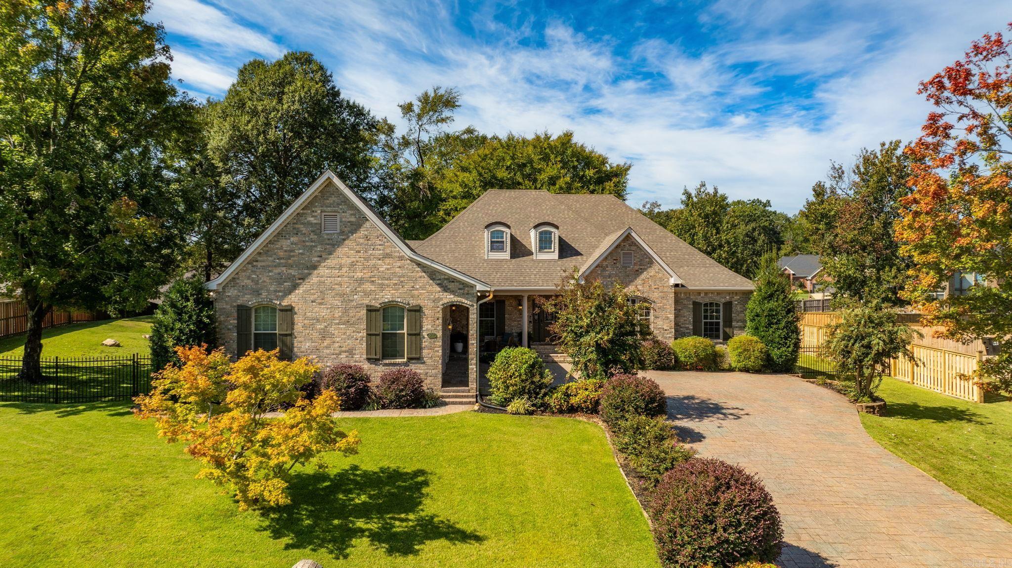 Spectacular home in Hurricane Lake Estates with a lake view! A stamped driveway & well-manicured landscaping welcome you.  Inside, a lovely entry opens to 10-foot ceilings, new LVP floors, a charming stone fireplace with a brand-new mantle, and a formal dining room Perfect for everyday living or entertaining. Designed to live like a one-level, the main floor features a spacious primary suite complete with an office, laundry, and living area, along with three additional bedrooms. Upstairs, a bonus playroom offers flexible space for work or play. The garage and 8x10 shop feature sleek epoxy floors, with recent improvements including a bonus room, new HVAC, hot water heater, and a full house generator. Outdoors, the oversized backyard offers a private retreat with a shaded back porch, mature trees, and a fully fenced yard with wrought iron accents in front and wood fencing along the sides and rear. Truly a rare find you won’t want to miss!