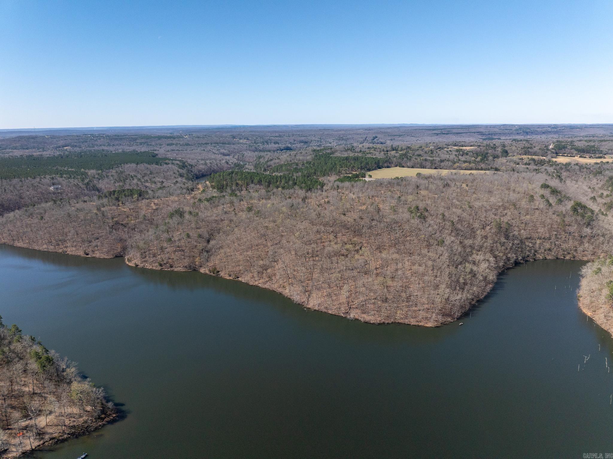 Wedding chapel or event venue opportunity in Romance, Arkansas! Investors, here's a chance to create one of the area's most scenic venues in a location with a name that's impossible to forget.  Red Bluff on Barnett Lake offers some of the most stunning vista views in the region. With over a mile of frontage along Barnett Lake, the property features panoramic views from the “Red Bluffs” on the east side. The elevated terrain provides sweeping sightlines across the surrounding landscape, capturing the beauty of the northern Ozarks in central Arkansas.  This property showcases exceptional scenery with a diverse mix of land features, including approximately one mile of lake frontage, mixed pine and hardwood timber, and an open field near the center of the property. The combination of habitat and water access supports outstanding wild turkey and deer hunting, along with direct fishing access on Barnett Lake.  Access off Gravel Hill Road near Floyd. Its location places it less than 45 minutes from Little Rock and under 40 minutes from Conway. An improved interior road provides access to the central portion and multiple potential building sites.