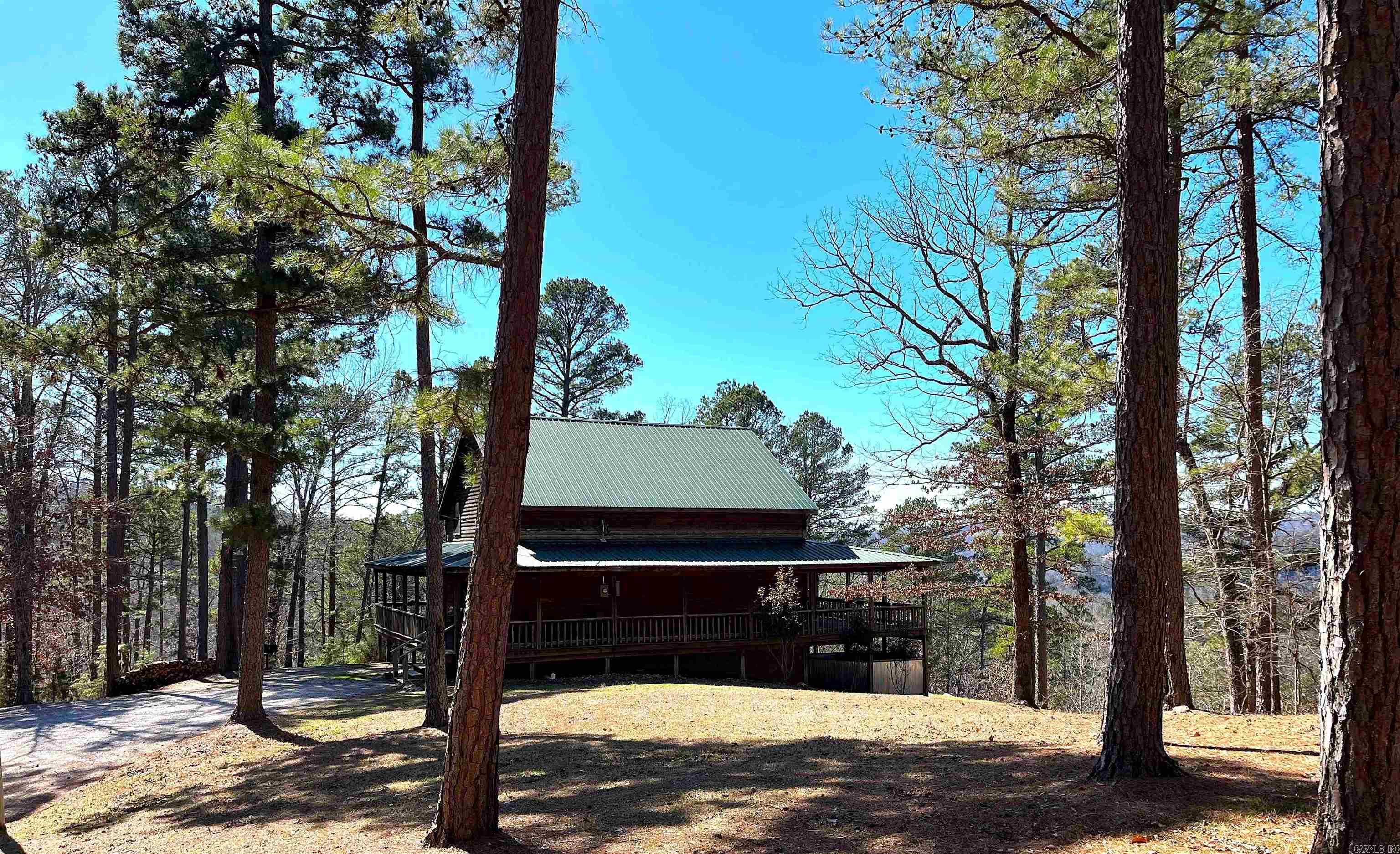 Custom cabin perched high on a mountain in a beautiful, gated cabin community. The cabin was strategically built to take advantage of the gorgeous views looking over the White River Valley. Built in 2008, there's 5 sleeping areas and 2 full baths. The living area has a vaulted ceiling, floor to ceiling propane fireplace and floor to ceiling windows. The kitchen is very spacious with an island and a bar. Master bedroom is on the main level featuring large windows with big views and access to the covered deck. Upstairs is a large sitting/tv area, 2 guest bedrooms and guest bath. The finished basement has 2 sleeping areas, game room and a tv area. The wraparound porches provide plenty of outdoor entertaining or relaxing areas. The 13+/- acres is very diverse with woods, trails, seasonal waterfall and spectacular views. An outdoor shower lets you clean up after a busy day exploring. White River public boat ramp is approximately 1.6 miles away. You are only minutes from the National Forest, Blanchard Springs Caverns and all Mountain View have to offer. Property is currently on a successful nightly rental program. Restrictions are in place to protect your investment.