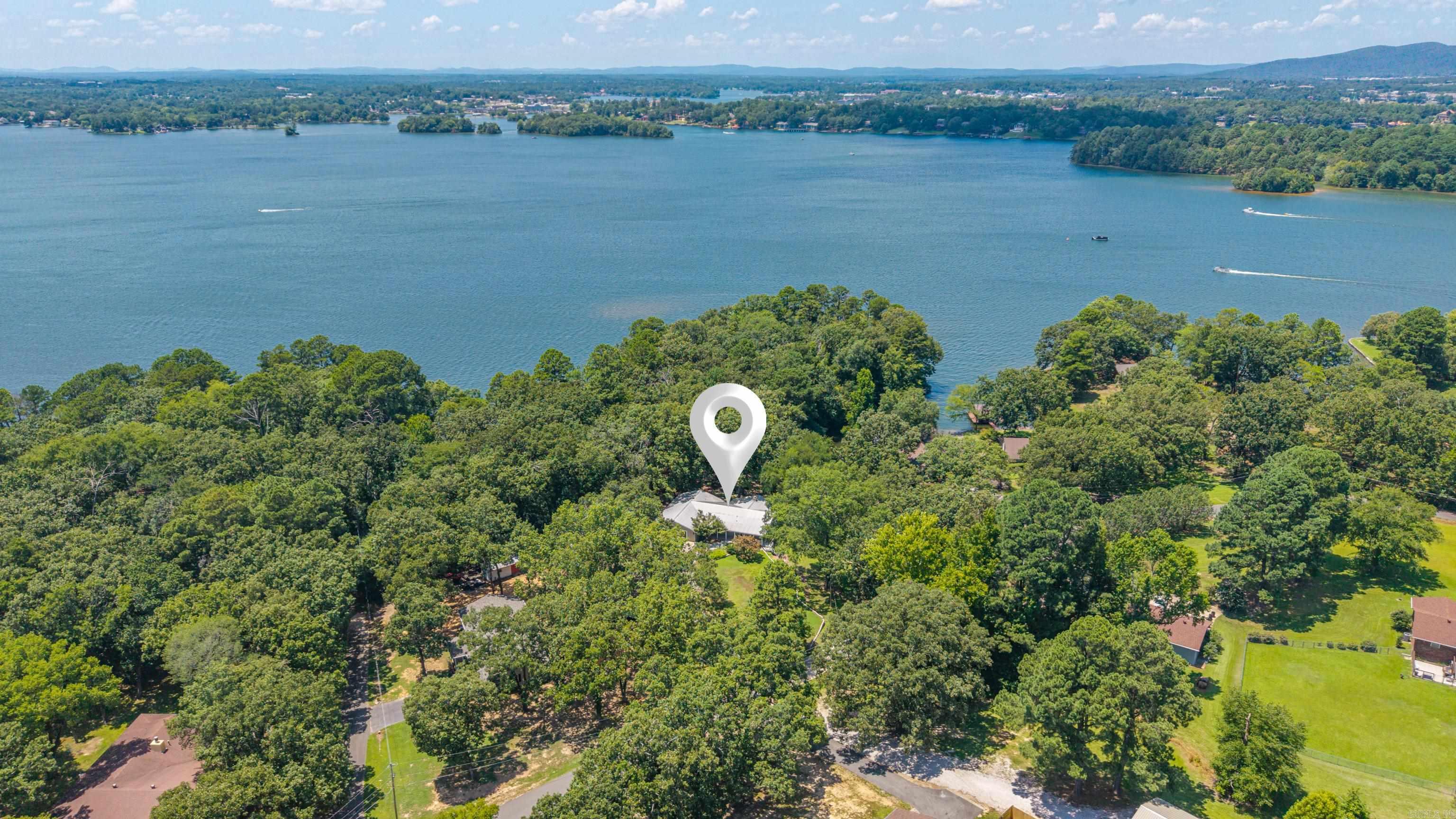 Big views.Big space.Big opportunity.Affordable Lake Hamilton waterfront home with room to make it your own. 5 bedrooms and 3 full baths, this property is priced for immediate sale, leaving plenty of room in your budget for updates that reflect your style.Wall-to-wall windows showcase the beauty of Lake Hamilton and fill the home with natural light. The spacious primary suite and 2 guest bedrooms all open onto an oversized lakeside deck—the perfect place to entertain, relax, or enjoy life on the water.A custom bunk room is built for unforgettable lake weekends, while the bonus flex space is ready to become a game room, home theater, fitness studio, or additional sleeping quarters.Just a hop, skip, and a jump away, the neighborhood boat launch makes getting on the water quick and easy. Outside, a massive greenhouse and private well create the perfect setup for gardening enthusiasts or anyone with a green thumb.The location is where this property truly shines. Situated in the county, no short-term rental permit is required, creating exceptional vacation rental potential.Whether personal home or investment, this property offers the space, location, and flexibility to make it happen.