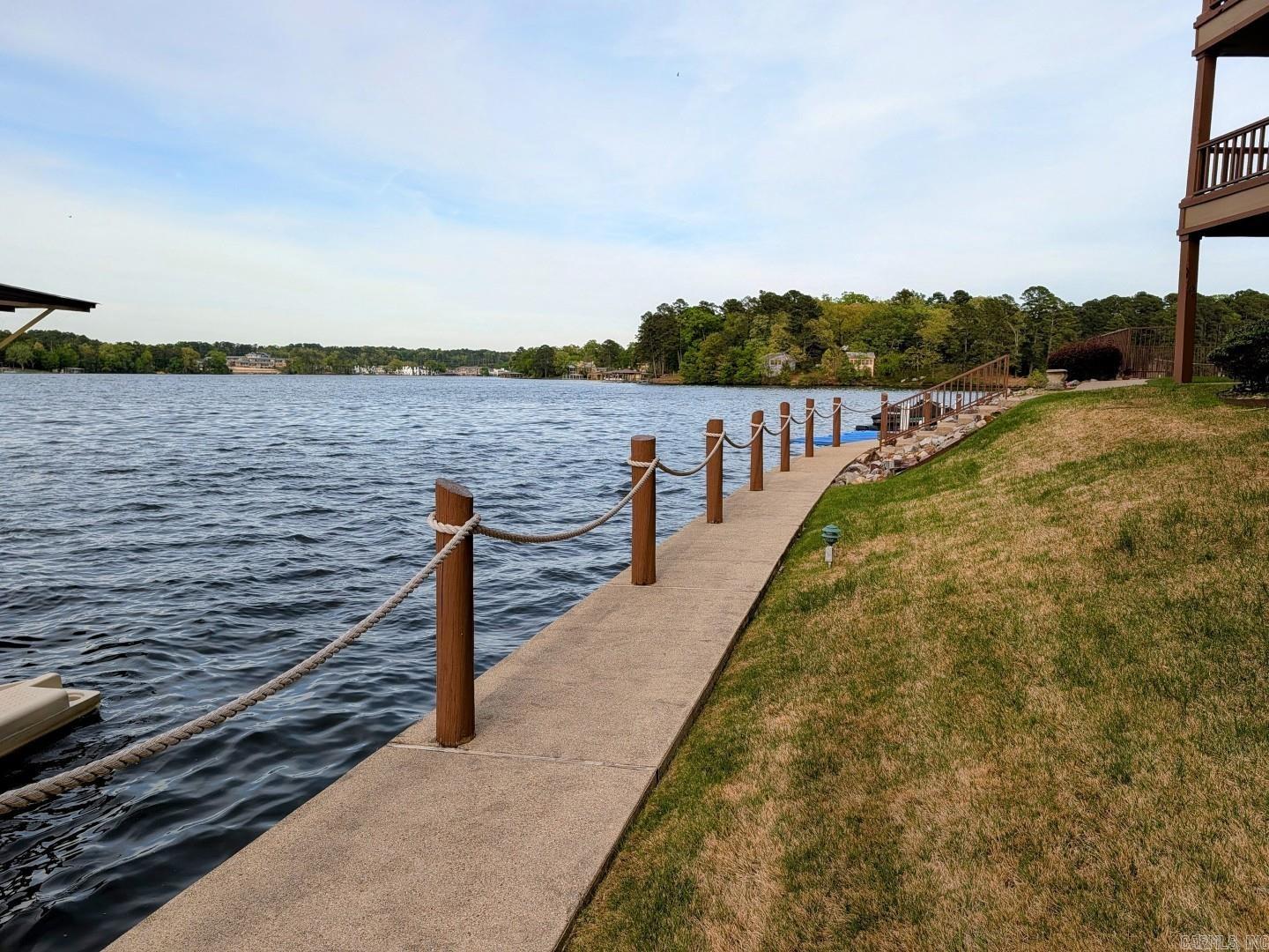 Escape the hustle and bustle of crowded weekend rentals and discover the tranquility of Lake Port, one of Lake Hamilton's exclusive, long-term-only gated communities.  Nestled within a well maintained lakeside complex, this charming Lake Port condo presents an exceptional opportunity to experience the best of relaxed lake living. The property boasts an array of desirable amenities, including a pool, lakeside boardwalk and beautifully landscaped grounds. Imagine starting your days with a cup of coffee or unwinding in the evenings, enjoying your surroundings from your private balcony. Furthermore, the property includes a covered boat stall with a lift, perfect for the boating enthusiast. This two-bedroom, two-bath condo seamlessly blends comfort and sophistication, offering the ideal setting for creating lasting memories. Embrace the opportunity to personalize this beautiful space and make it your own tranquil lakefront haven. With nightly rentals strictly prohibited in Lake Port, residents can enjoy an unparalleled sense of peace and quiet. No wear and tear from rental traffic here.
