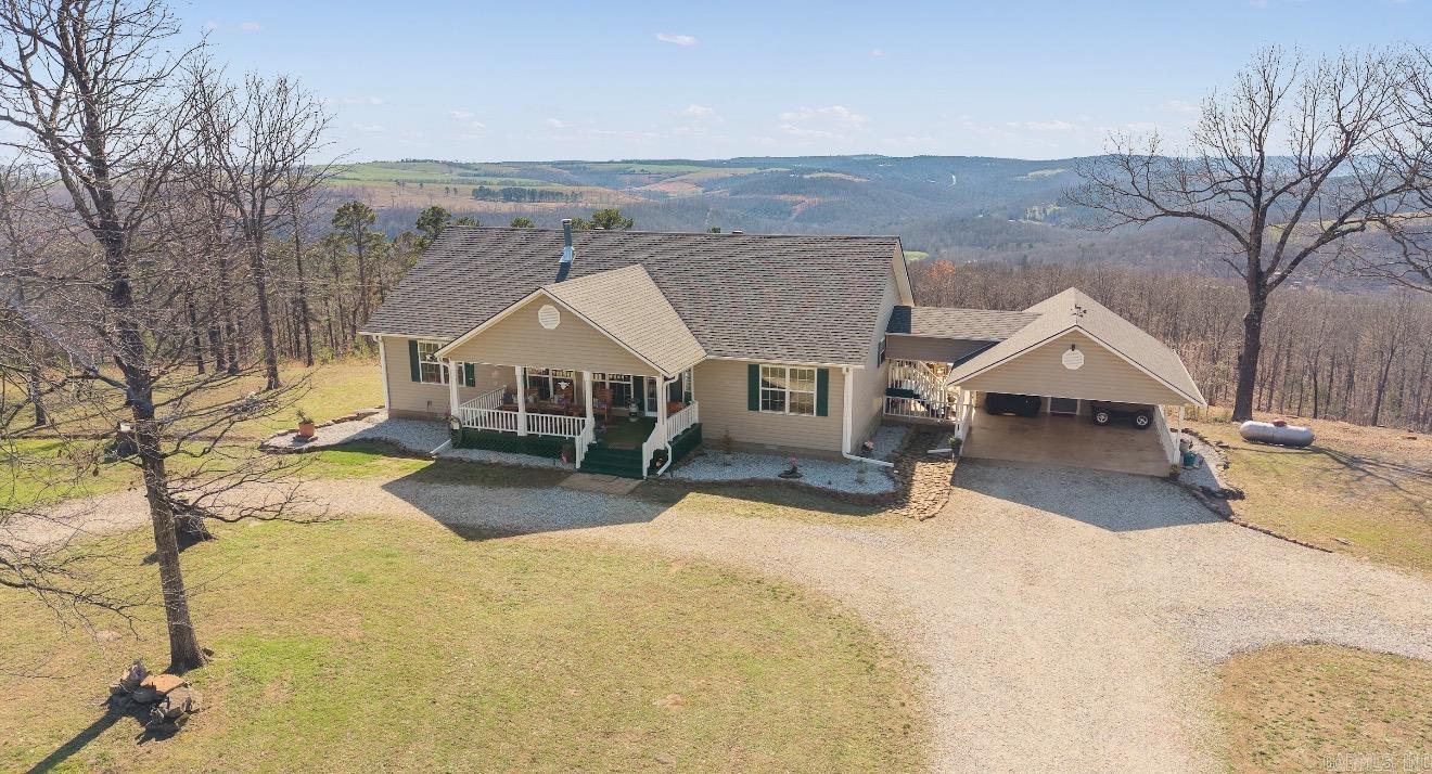 Sitting at the very top of the mountain with total privacy/no neighbors in sight. This breathtaking 38.36+/- acre Ozark retreat offers panoramic views for miles. The outdoor paradise includes ATV trails, deer box blind, wet-weather creek, pond, garden, & perimeter firebreak. Wildlife: including deer & turkey roam the vast majestic landscape. The 392 sf studio cabin w/bath & kitchenette is ideal for guests, office, or rental income. The 2-Bed, 2-Bath 2,016 sq ft home has an open-concept living, beautiful hardwood floors, spacious living room w/cozy pellet stove. Kitchen offers stainless steel appliances 2024/25, opens to four-season sunroom w/walls of windows showcasing the natural beauty of the Ozark Mountains. Relax on the spacious covered front porch or soak in stunning expansive views from the newly rebuilt back decks 2025. The private master suite features: walk-in closet, walk-in shower, dual vanities, & whirlpool tub. Additional highlights: Spacious utility room, architectural shingle roof 2023, gutter system 2025, high-efficiency HVAC 2024, & fiber internet. Custom log furnishings & additional furnishings may convey at an additional value. Contact listing agent for details.