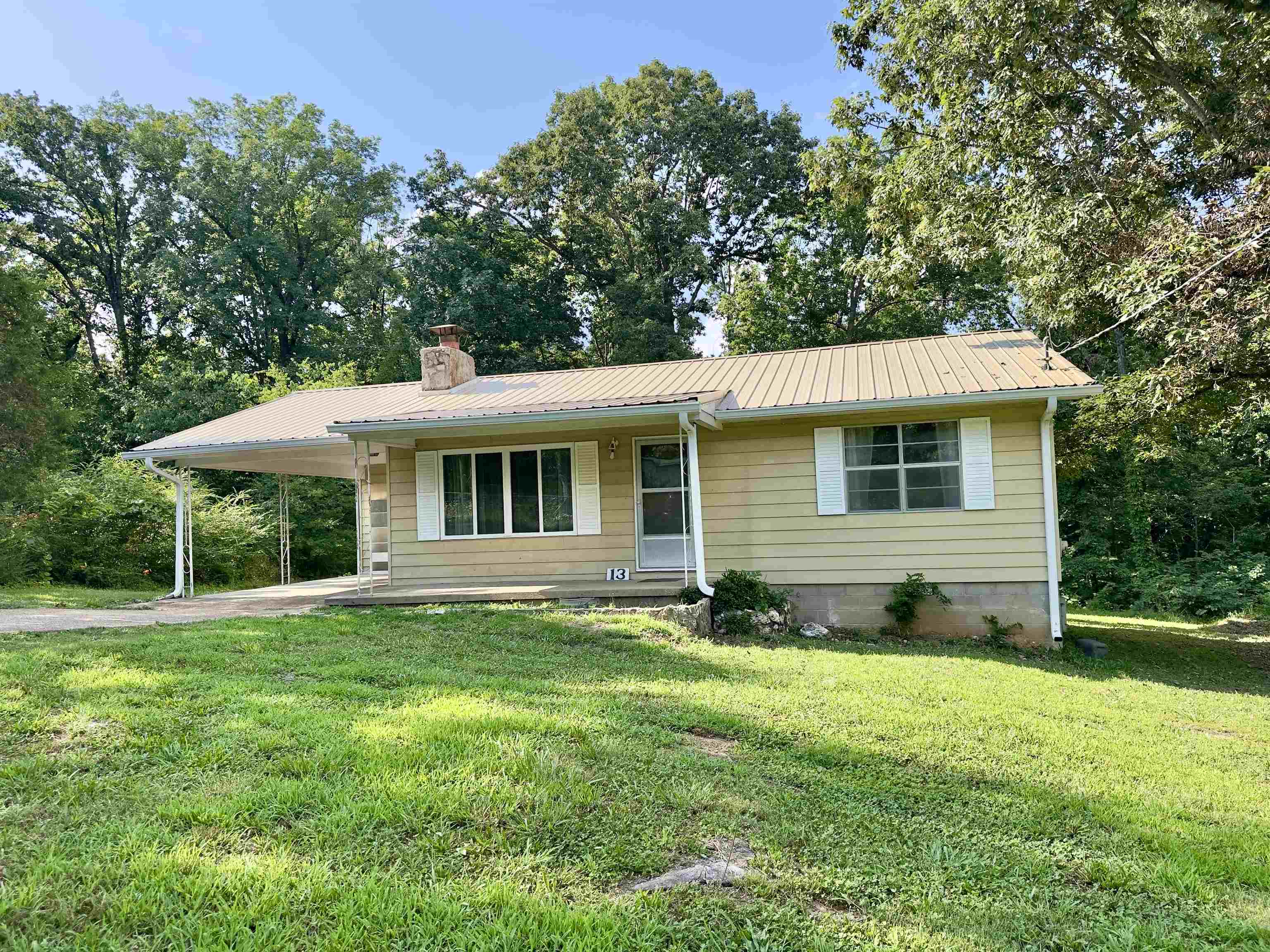 This cozy two bedroom, one bath home is located on an oversized lot in the LAKE community of Ozark Acres, offering easy access to Highway 63, two private lakes, community center and more.  Features include a level lot, nearly new roof, a walk-in shower, new flooring, wood burning fireplace, large mud room (that contains the laundry), covered parking, large picture window in the living room streaming natural light! You will love sitting on the covered back porch enjoying privacy and natural wooded views. Move in ready!