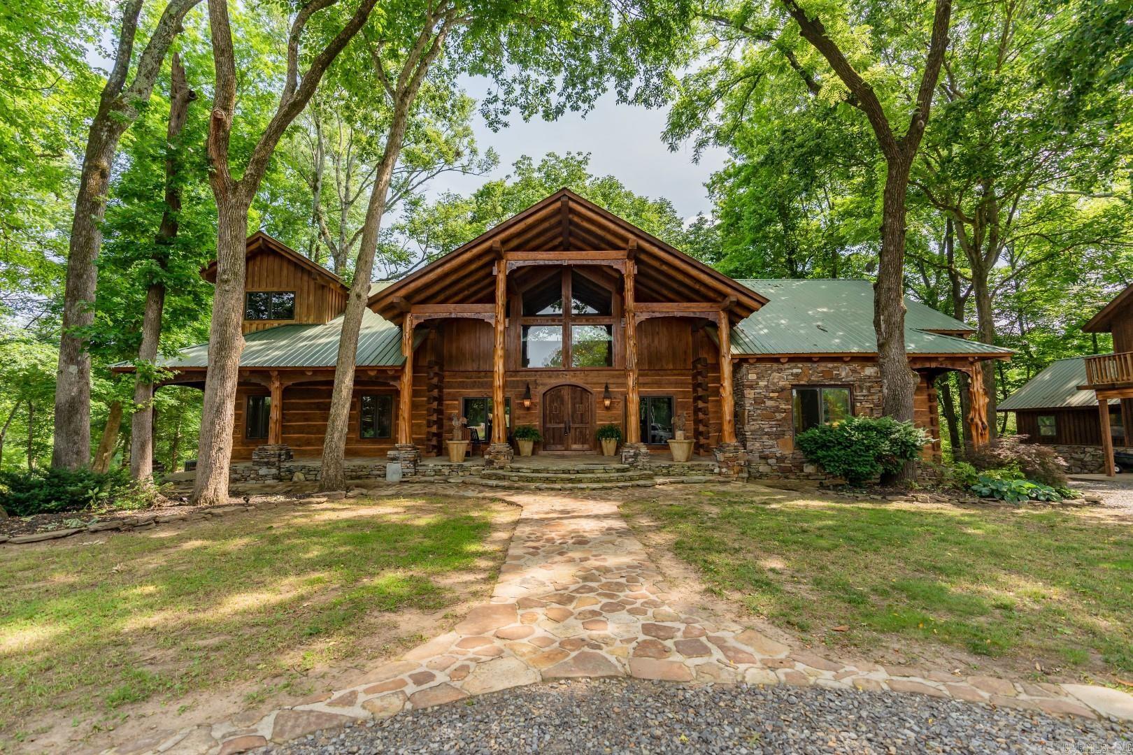 Spectacular Little Red River home on 2 river lots!  This 5-bedroom 3.5 bath home has options for more bedrooms if needed!  Made from very high-end log construction, this home includes a massive main living area with 2-story ceilings, a large dry-stack stone fireplace, exposed logs and beams, wood floors, multiple balcony and living areas, luxurious kitchen with granite tops, tile floors, 8-burner Viking cook-top, spacious breakfast bar, cozy office, incredible master suite with private loft, large boat dock with huge fishing platform, firepit, basement-area kitchenette, downstairs fireplace, wine room, garage storage, covered parking with apartment above, massive covered deck overlooking the river, easy walk to the dock, metal roof, stone patios and much, much more!  A lovely, well-cared-for home!