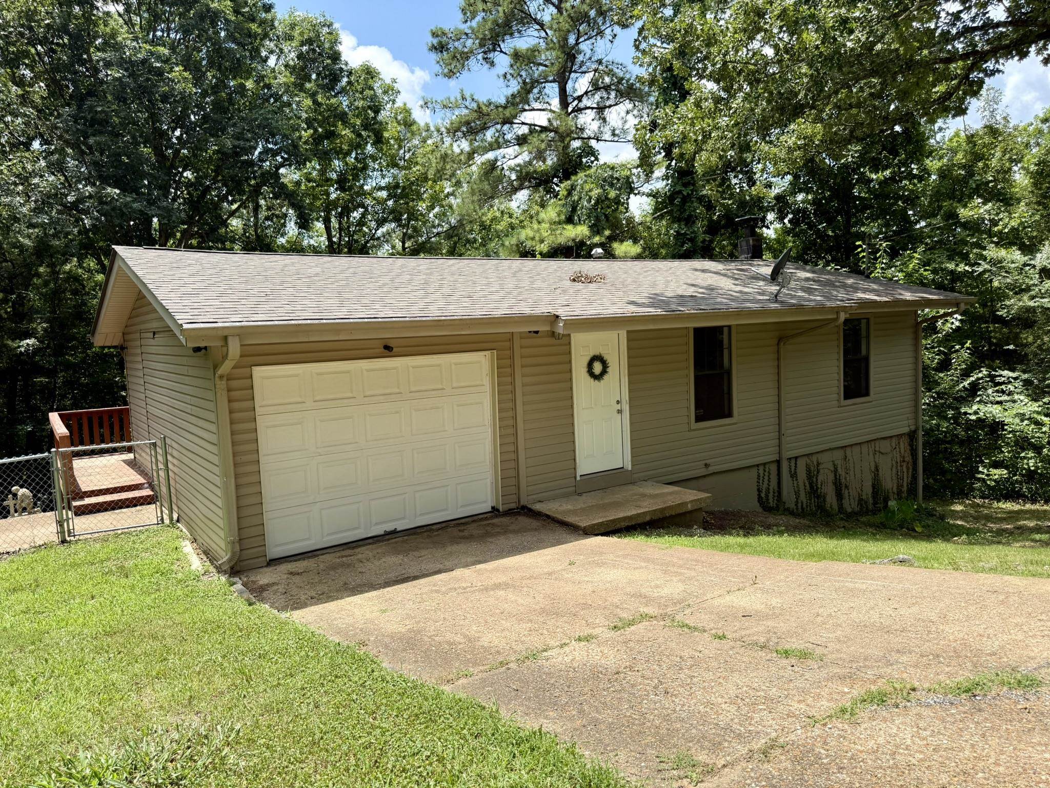 Located at 1 E Ute Circle in Cherokee Village, Arkansas, this 3-bedroom, 2-bath multi-level home sits on four heavily treed lots, offering a wooded setting with privacy and a natural backdrop. The property includes a fenced backyard and is located within a short drive of Cherokee Village lakes, golf courses, and area amenities. The upper level features the primary bedroom, living room, and kitchen. The primary bedroom includes a large walk-in closet. The lower level includes two additional bedrooms, providing a practical layout for family, guests, office space, or additional living needs. Each room offers ample closet space for storage. This Cherokee Village home offers a combination of residential space, multiple lots, and access to nearby outdoor recreation, including area lakes and golf courses. Listed for $159,900.