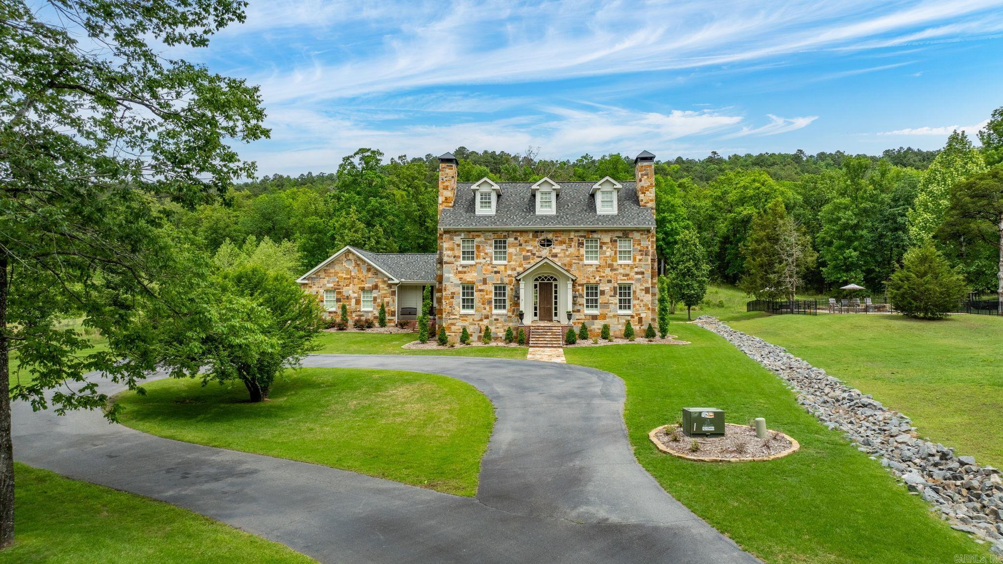 Exceptional custom estate on 28 breathtaking acres just minutes from the Kanis/Ferndale four-way stop and Chenal. This stone and frame residence offers the perfect blend of luxury, privacy, and convenience. Designed for family living and entertaining, the home features expansive living and dining spaces, a private office, gourmet kitchen, and inviting family room with a stunning stone fireplace. The main-level primary suite offers a spa-inspired bath and dual walk-in closets, while four additional bedrooms, a media/playroom, and built-in study area provide ample space for family and guests. Step outside to a spectacular covered patio overlooking the pool and stone terrace, all surrounded by the natural beauty and seclusion of 28 remarkable acres. Additional highlights include a gated entrance, three-car garage, whole-house generator, and new roof (2023). A rare opportunity to own an extraordinary acreage estate offering the tranquility of country living with the convenience of being just minutes from Little Rock amenities.