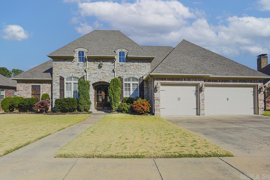 This stately stone and brick home is nestled on a quiet Cul de sac in the prestigious Overbrook neighborhood of Sherwood. This home boasts a blend of elegance and comfort. As you enter the doubled arched doors into the inviting foyer you are flanked by a comfy den/office on one side and the grand dining room on the other - both with plantation shutters. Through the doorway you will enter the heart of the home which is the large great room with gleaming hardwood floors, bright wall of windows, stunning coffered ceiling and a warm stone fireplace complemented by built ins. The kitchen is a chef's dream featuring granite countertops and tumbled stone tile backsplash. A large island, gas cooktop/stove, refrigerator and microwave convey and there is also a spacious walk-in pantry. The primary BR is extra-large with a wonderful bath with tub and walk in shower plus a large walk-in closet. Two other bedroom suites round out the main floor with a half bath and laundry room. A bonus room awaits upstairs for storage, game room, home theater, etc. A partially covered back deck and roomy three car garage with built in cabinets for ample storage completes this beautiful home. Come see!