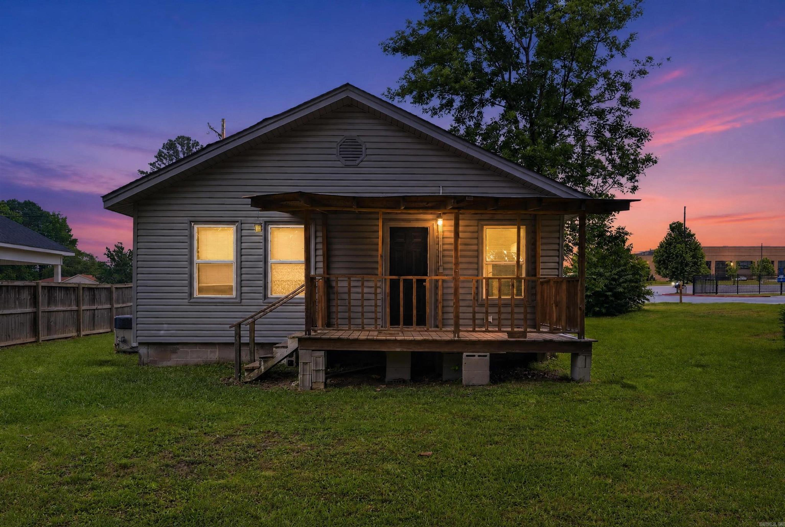 This charming 2-bedroom, 1-bathroom traditional single-story cottage offers 959 sq. ft. of comfortable living space. Ideally situated in a prime location directly across from Bryant High School, the property places you minutes away from local shopping and dining options.  The home sits on a beautiful, level lot framed by mature shade trees, offering great outdoor potential. Notable exterior features include a covered parking area, a dedicated storage shed, a classic screened front porch, a back deck, and an installed storm shelter for absolute peace of mind. Inside, enjoy a functional eat-in kitchen layout and central climate control.