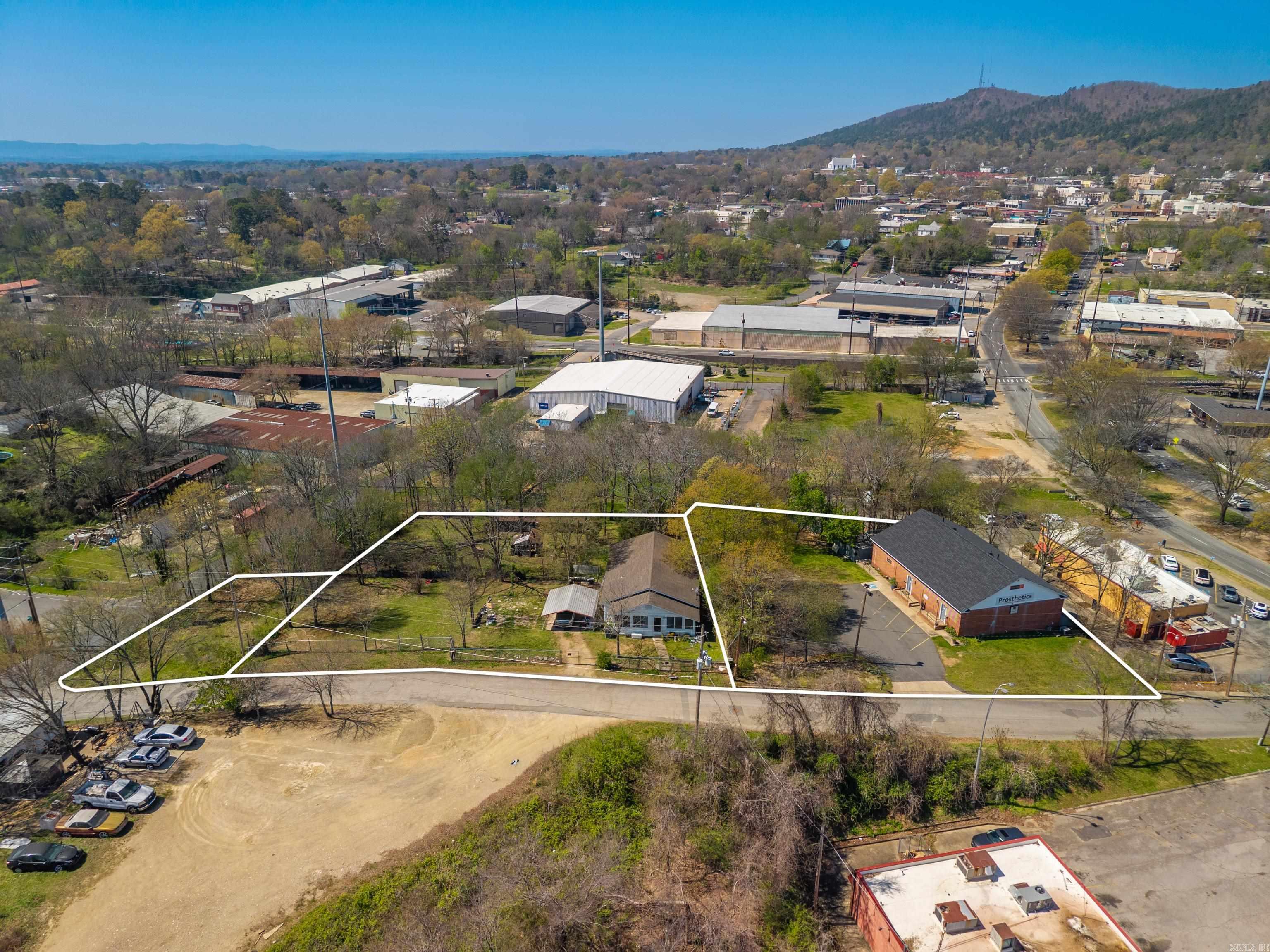 1.22 acres in the city limits! 3 PRIME PARCELS available near downtown Hot Springs - all ZONED COMMERCIAL.Adjacent to the Gateway Reviltilization Project on Malvern Ave, and one block from the the Greenway Trail along Hot Springs Creek.  Perfect for redevelopment or immediate use, this property includes an existing office building, a house, and a vacant lot offering flexibility for investors, businesses, or mixed-use projects. Ideal for office, retail, or hospitality development. 120 Hill street Suites A & B was built in 1975 and the roof was replaced in 2024. Suite A currently houses Mobility Prosthetics which has a 2 year lease. Suite B is an office/apartment with full bathroom & kitchen.  124 Hill St is a 1280 sq ft home built in 1938 but updated and has a new HVAC. Current tenant is month-to-month