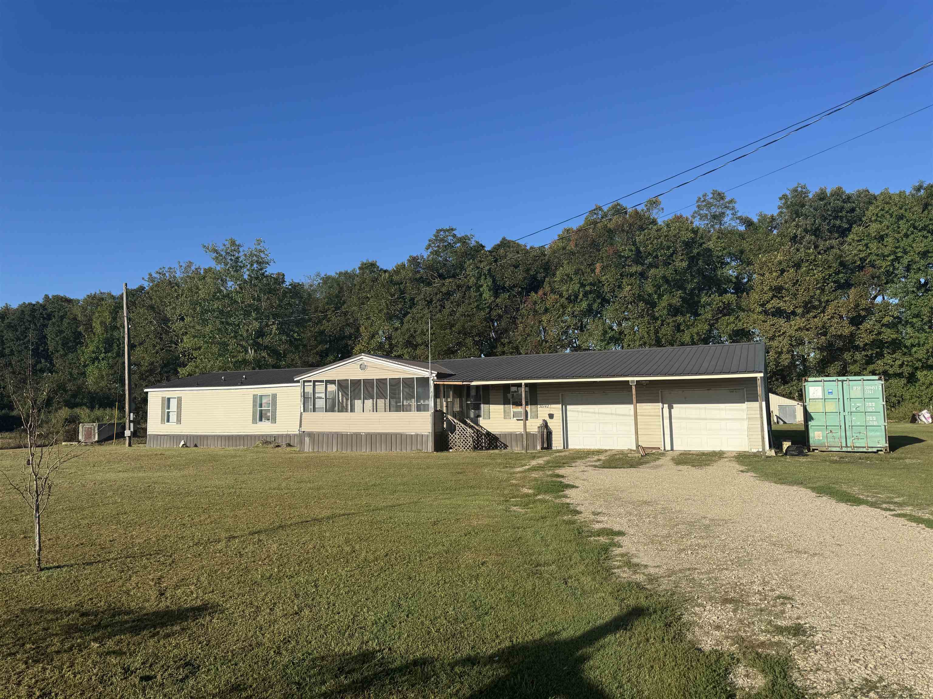 Spacious country living just minutes from town! This 1998 doublewide mobile home offers over 2,000 sq ft of living space with 5 bedrooms and 3 full baths, perfect for a growing family or anyone needing extra room. The home includes a full 2-car garage, large shop out back, and a storm shelter for peace of mind.  Sitting on 2.9 beautiful acres, part of the property is fenced and ready for your horses or livestock. Recent updates include a new metal roof (10 years old), outside HVAC unit (2 years old), and new underpinning (3 years old).  This property has great bones and just needs a little work to make it your own. Enjoy the space, safety, and serenity of country living — all at an affordable price!  Enjoy peace, space, and endless potential — all at an affordable price!