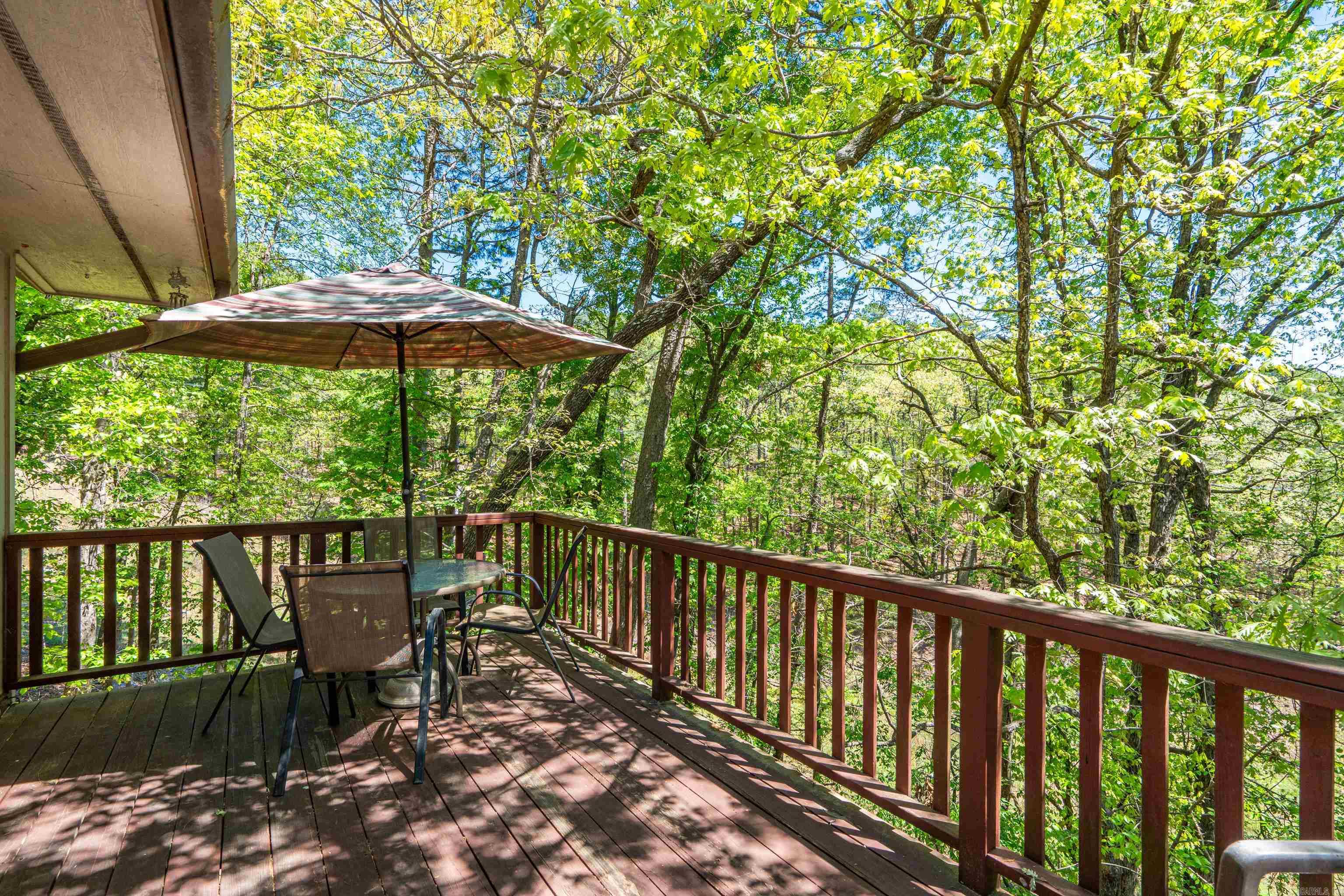 Move-in ready, fully furnished end-unit townhouse nestled in a peaceful wooded setting in Hot Springs Village! This updated 3-bedroom, 2-bath home offers 1,402 square feet of comfortable living across two levels with a flexible floor plan ideal as a primary residence, vacation home, second home, or investment property. The main level features an open living and dining area with abundant natural light and direct access to a private deck overlooking the trees—perfect for relaxing, entertaining, or enjoying your morning coffee. A main-level bedroom and full bath provide convenient single-level living for guests or everyday comfort. Downstairs, you'll find two additional bedrooms, a full bath, laundry area, and a versatile bonus room perfect for a home office, hobby room, fitness space, or extra storage. A second private deck extends your outdoor living space and is accessible from the lower-level bedroom. Located in the highly sought-after Hot Springs Village, you'll enjoy world-class amenities including championship golf courses, lakes, marinas, pickleball, tennis, hiking and biking trails, fitness facilities, restaurants, and more. New Roof in July 2026! Call today!