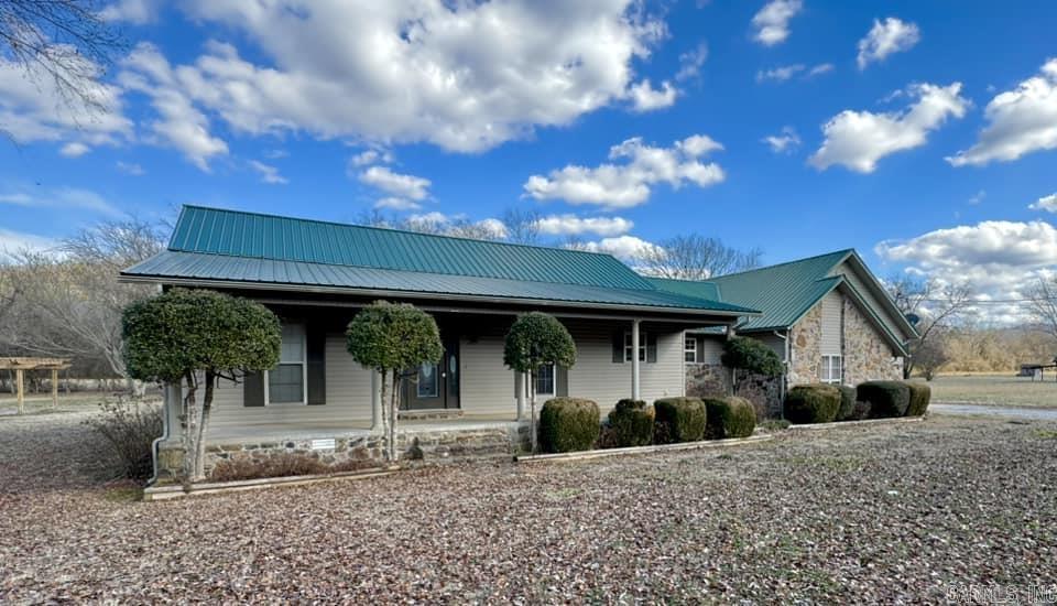 This charming 3 bedroom, 2 bath with the primary bedroom and bath separate from the 2 guest bedrooms. Open kitchen and dining room with a large, vaulted ceiling living room with a beautiful rock fireplace that leads out to a covered sun porch with mountain views all around. The kitchen offers ample cabinet space and a pantry which leads to large separate utility room and the 2-car attached garage for plenty of room for vehicles and storage.  Only a few miles from downtown Mtn View and just a walk across the road to the White River.