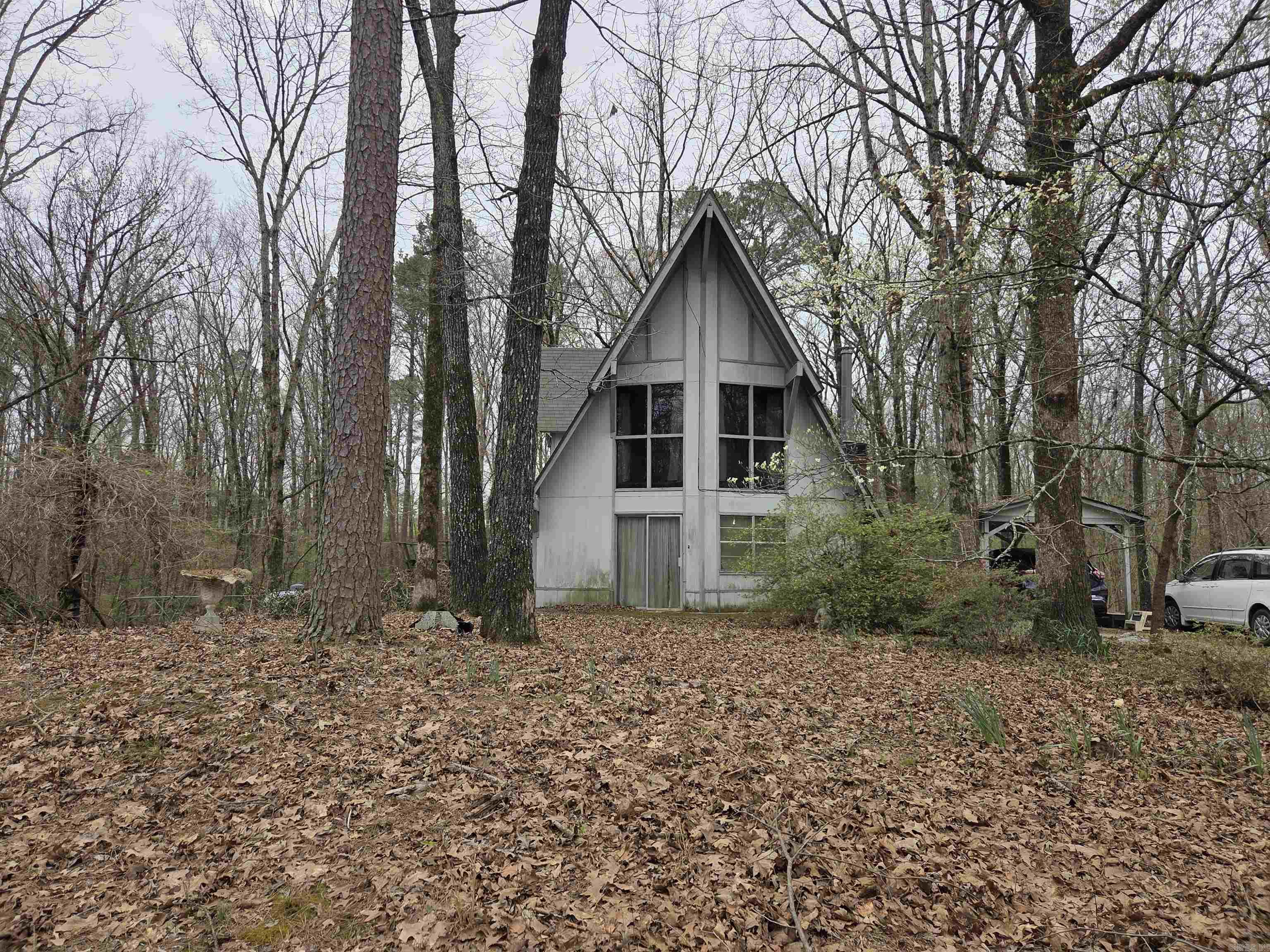 Tucked away among the trees on 2.25 acres, A-frame home offers the perfect blend of privacy and character. Located outside city limits, you’ll enjoy a peaceful, secluded setting while still being within reach of town.  This estate needs work, and will be sold as is and is priced accordingly.  The unique layout features a cozy yet functional design, including an inviting upstairs retreat complete with its own private bathroom—ideal for guests or a primary suite. Step outside to relax or entertain around the above-ground pool, surrounded by nature. If you’re looking for a distinctive home with space to unwind and room to breathe, this house is a must-see!"   NOTE:  This Property is sold "As Is".  Newer Roof, Newer A/C Unit, Generac Generator.