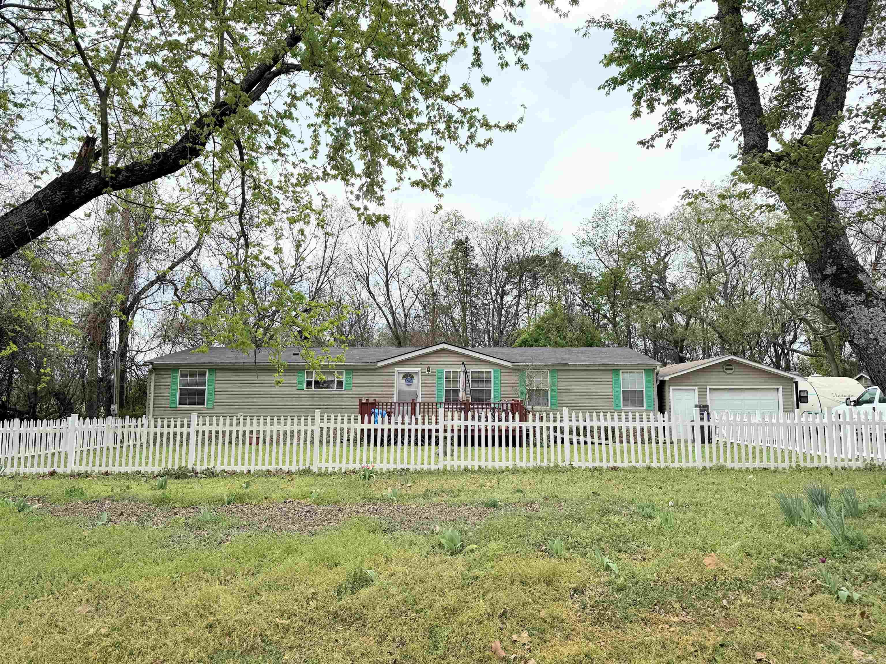 Welcome home to this beautiful and spacious 3-bedroom, 2-bath manufactured home featuring a desirable split floor plan. Inside, you’ll find cozy living spaces with a wood-burning fireplace, walk-in closets, and plenty of room to spread out. Step outside to enjoy the large front deck or relax on the screened-in back porch, perfect for quiet mornings or evening gatherings. The property is shaded by mature trees and offers great outdoor features including a storm shelter, detached one-car garage, and a handy work shed. With a new roof installed in 2021, this one checks all the boxes!