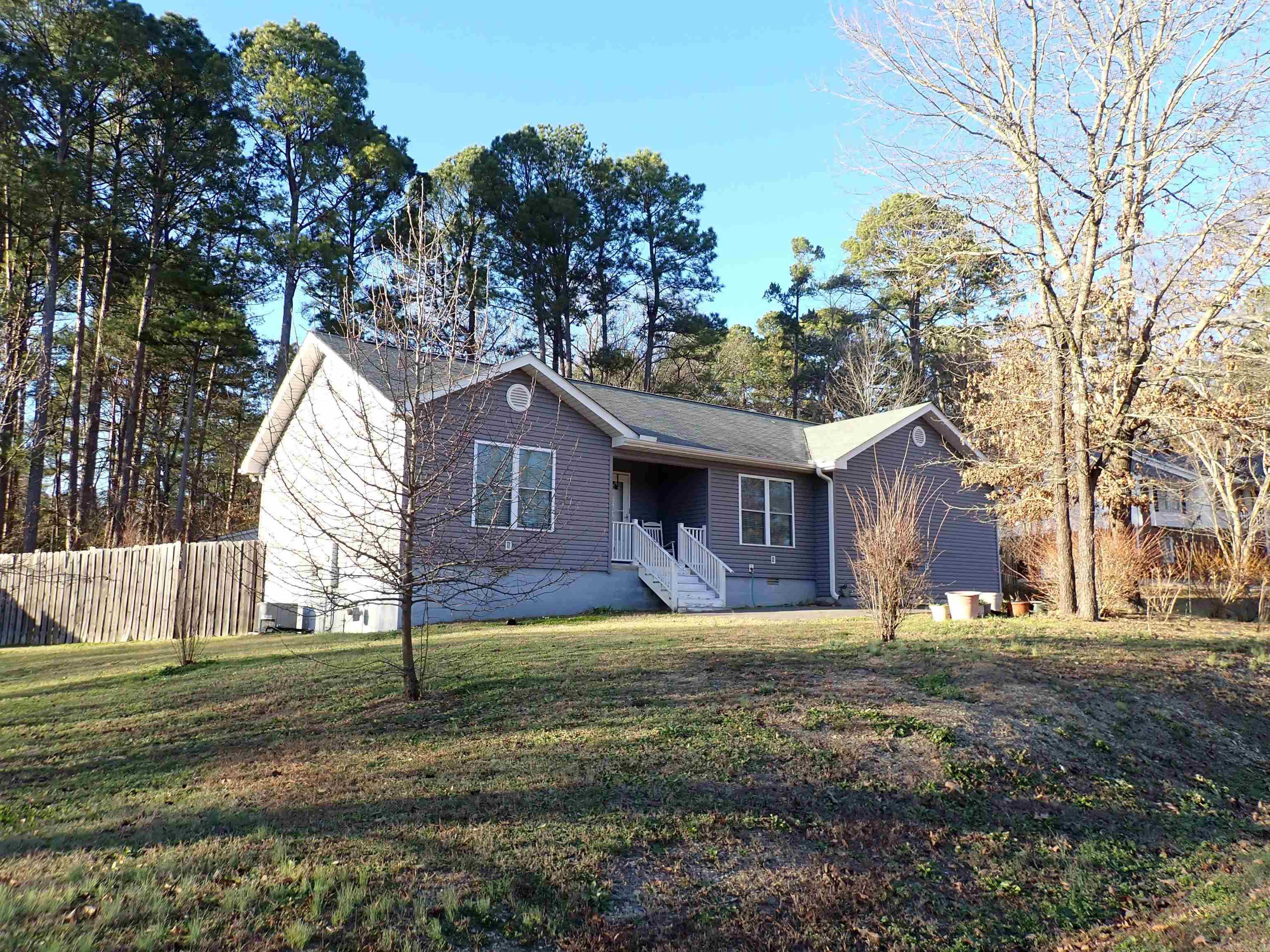 Located across the street from homes fronting Lake Hamilton, this 3-BR, 2-BA, 1-story home is on 2 LOTS (a corner Lot) with 8' tall privacy fencing.  NEW in 2015.  Grey vinyl siding with white trim.  Single garage with high ceiling.  Pier & beam foundation --- all exterior entrances (3) have multiple steps.  Large LIVING/DINING/KITCHEN combination, separated Bedroom arrangement, and a 'walk-thru' laundry room.  AWESOME FLOOR PLAN!  Two separate dining areas --- both visible in the Living/Dining/Kitchen combination.  Plus the front entry door -AND- the single French door to the FABULOUS, 8' x 20', COVERED BACK PORCH (deck with metal roof) overlooking the large, privacy-fenced back yard.  Stainless-finish appliances in kitchen --- including a NEWLY installed, decorative VENT HOOD above the free-standing, natural gas, cookstove.  So PRETTY!  BOTH bathrooms have walk-in showers, only.  The Primary bathroom has a wide vanity with TWO LAVATORIES.  Both bathrooms have a Linen closet -or- Linen cabinetry!  Laundry room has floor-to-ceiling shelving for household supplies and/or food pantry storage.  Walk-in closet in Primary-BR.  Unusually wonderful location --- Buyer will be very pleased!