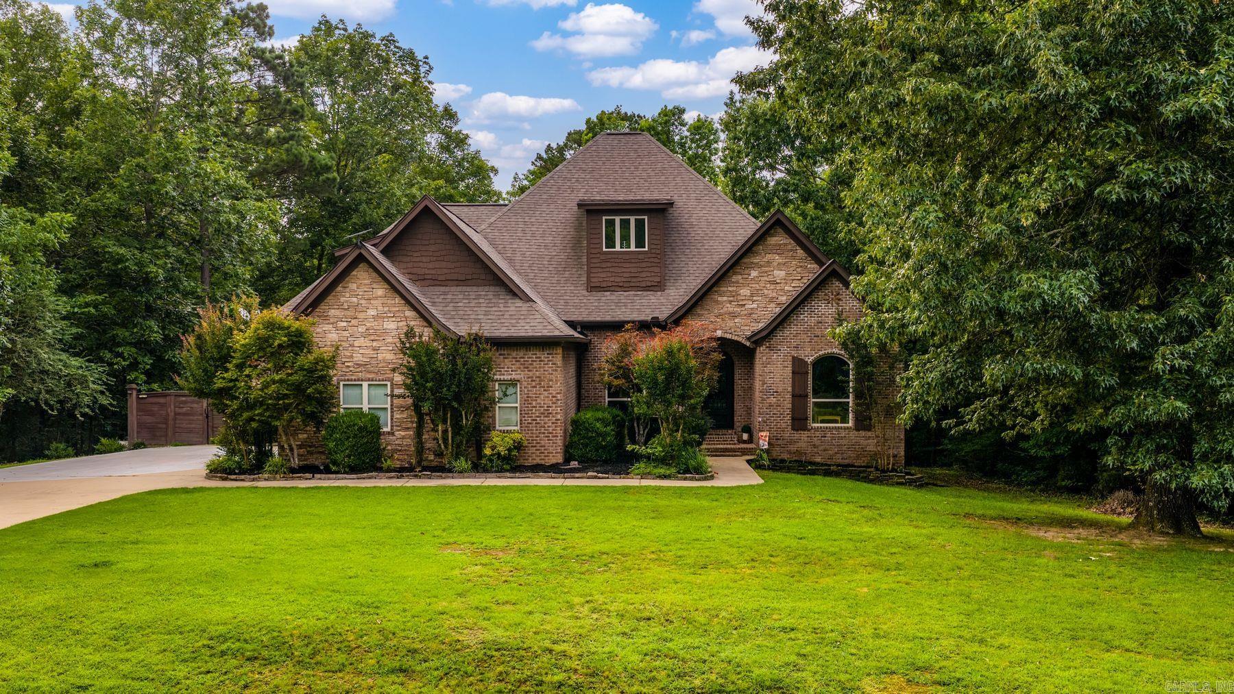 Welcome to your own private retreat! Nestled on approximately 5 beautifully wooded acres, this stunning custom home offers the perfect blend of comfort, space, and seclusion. Surrounded by mature trees, the property creates a peaceful setting with exceptional privacy while remaining just minutes from the conveniences of Benton. Inside, you'll find over 3,400 square feet featuring soaring ceilings, a desirable split floor plan, spacious dining area, dedicated office, and an oversized bonus room offering endless flexibility. The well-appointed kitchen showcases granite countertops, stainless steel appliances, custom cabinetry, and breakfast bar for everyday living and entertaining. The luxurious primary suite provides a relaxing escape, while generously sized secondary bedrooms ensure room for everyone. Step outside to enjoy the tranquil landscape complete with updated landscaping, sprinkler system, and plenty of room to explore, entertain, or simply unwind. A side-load 3-car garage completes this exceptional property. New AC unit Feb. 2026, whole home generator and a safe room in the garage. This home is the perfect combination of privacy, acreage, and quality craftsmanship!