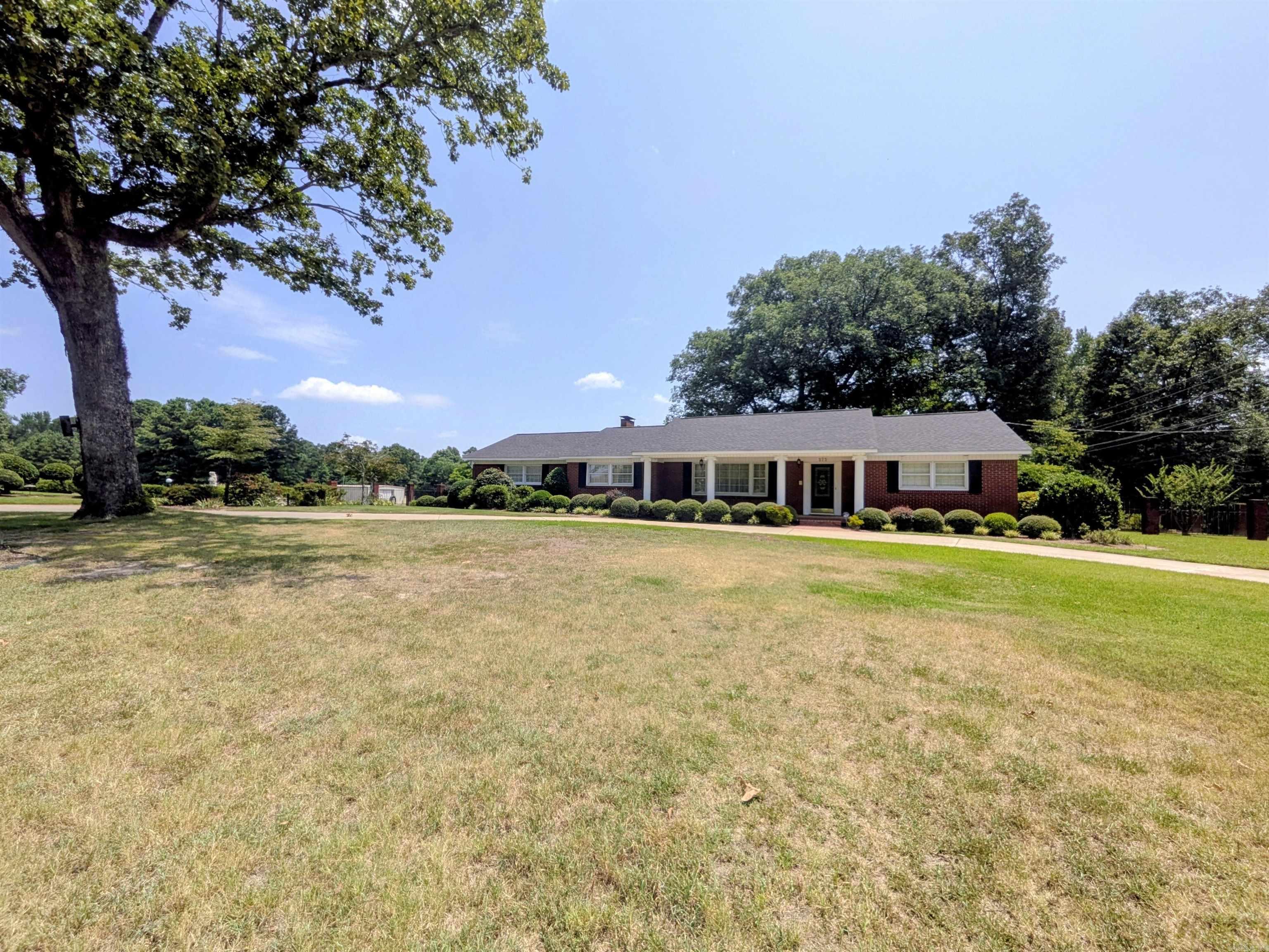 Beautifully maintained brick home on 5+ acres w/ gorgeous landscaping & a circular drive! This inviting home features a spacious living/dining room with wood floors & an elegant chandelier. The adjoining family room offers a gas fireplace & new carpet extending through the hallway & all bedrooms. The well-equipped kitchen includes a center island, tile backsplash, built-in pantry, & abundant cabinet space. Enjoy the bright sunroom w/ a wall of windows overlooking the beautiful backyard, plus a covered deck w/ cathedral ceiling! The spacious primary suite features a Jacuzzi tub & walk-in shower. Two add. bedrooms offer generous closets, and a third full bath is located off the laundry room. Crown molding throughout, mostly LED lighting, two attic access areas, two storage rooms in the carport, & numerous updates including a new furnace (5/26), roof (3-4 yrs), A/C (3 yrs), water heater (2 yrs), & newer gas lines. The 40x80 metal shop includes a thick concrete slab, office, half bath, & large overhead door - ideal for business, workshop, or storing equipment. A rare country property with room to work, live, & play! Square footage, acreage, and lot size taken from courthouse records.