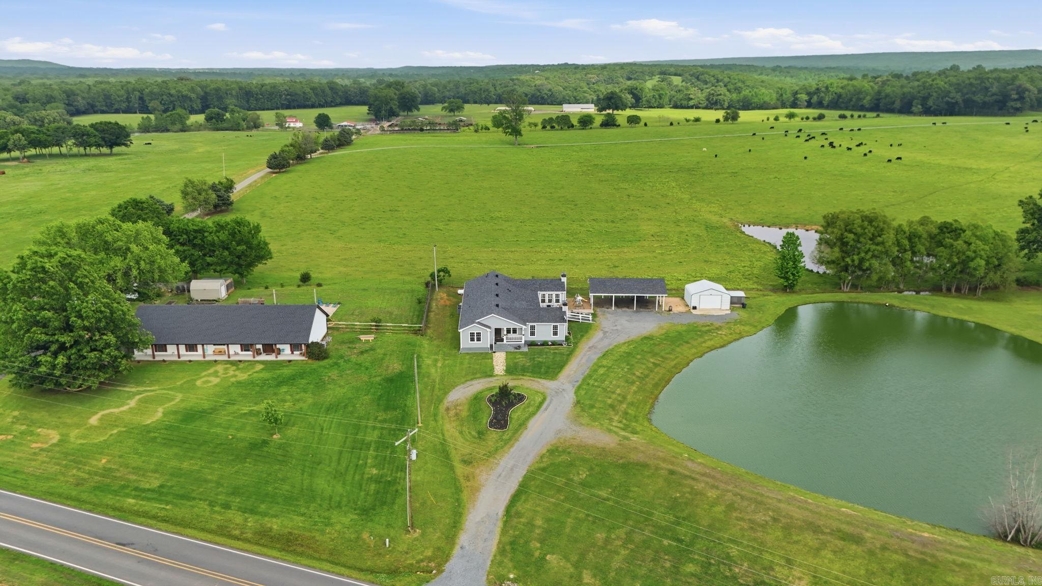 Welcome to this beautifully maintained 6-bedroom, 3.5-bath home on 3.72 acres. The property backs up to a massive open field that makes it feel like you're surrounded by endless space to breathe. Step onto the back deck, look out over the stocked pond, and take in wide open sky and rolling green as far as you can see. Inside, two living areas with wood burning fireplaces give you room to spread out, with abundant storage and closet space throughout. The home has been thoughtfully updated with fresh paint inside and out, new flooring, a new roof, LeafFilter gutters, updated decks, and two HVAC units replaced in 2019. Outside, a covered porch and large deck overlook the pond and that incredible open backdrop. Fresh flower beds and a garden ready to plant round out the outdoor living. A 3-car carport, detached garage/shop with upper level storage, and an additional shop gives you all the space you need for hobbies, tools, and toys. This home also has space for an in-law quarters for multi generation living! Peace, privacy, & modern updates on nearly 4 acres. This is country living done right. Properties like this are rare, so schedule a showing and make it your next chapter now!