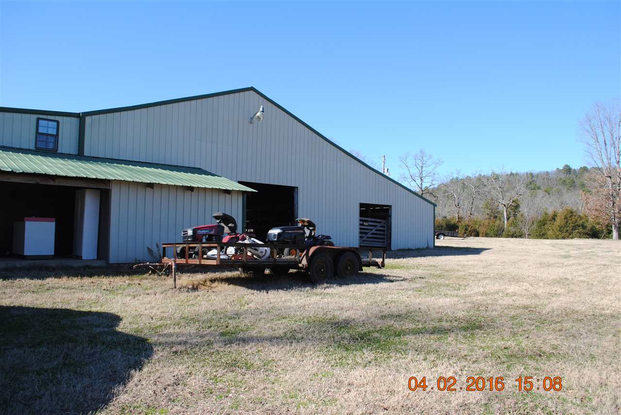Metal barn with hayloft and 4 stalls and 40x40 arena, apartment attached is more of a cabin "type" with all wood ceilings and walls made of red cedar cut from the property.  14.94 (aprox) acres, fenced and cross fenced with small stock pond.  Backs up to beautiful view of tree covered property (Green Bay Property).  Property is mostly bermuda pasture with some woods on the north and south sides.  Property is secluded, deer, turkey roam freely in the area.  Living space with about 70+' of 10' wide porch
